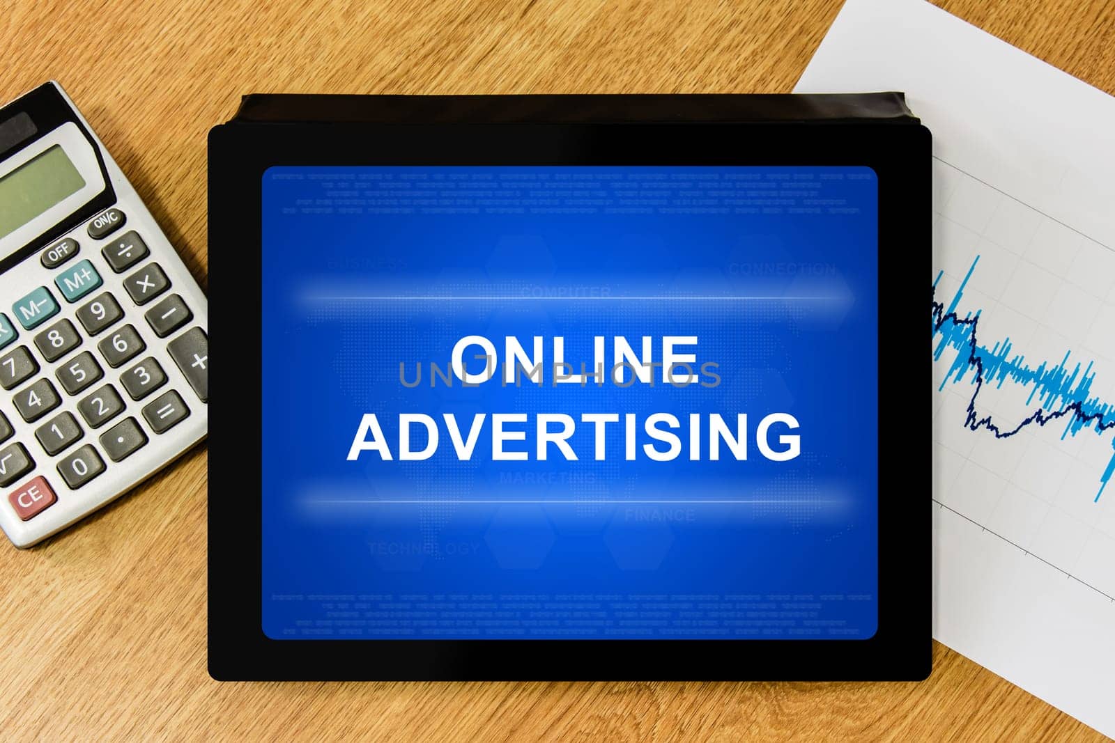 online advertising word on digital tablet with calculator and financial graph