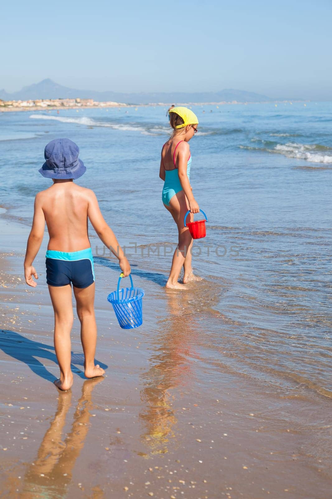 Cute kids looking for sea shells on the beach