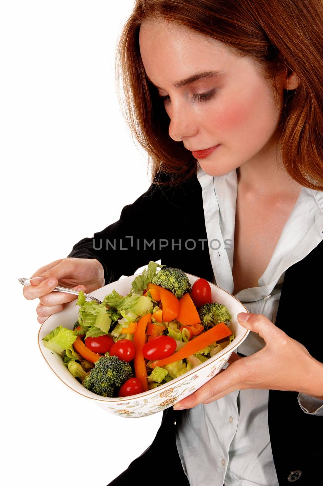 A young brunette woman holding a big bowl of salad and eating is,.isolated for white background..