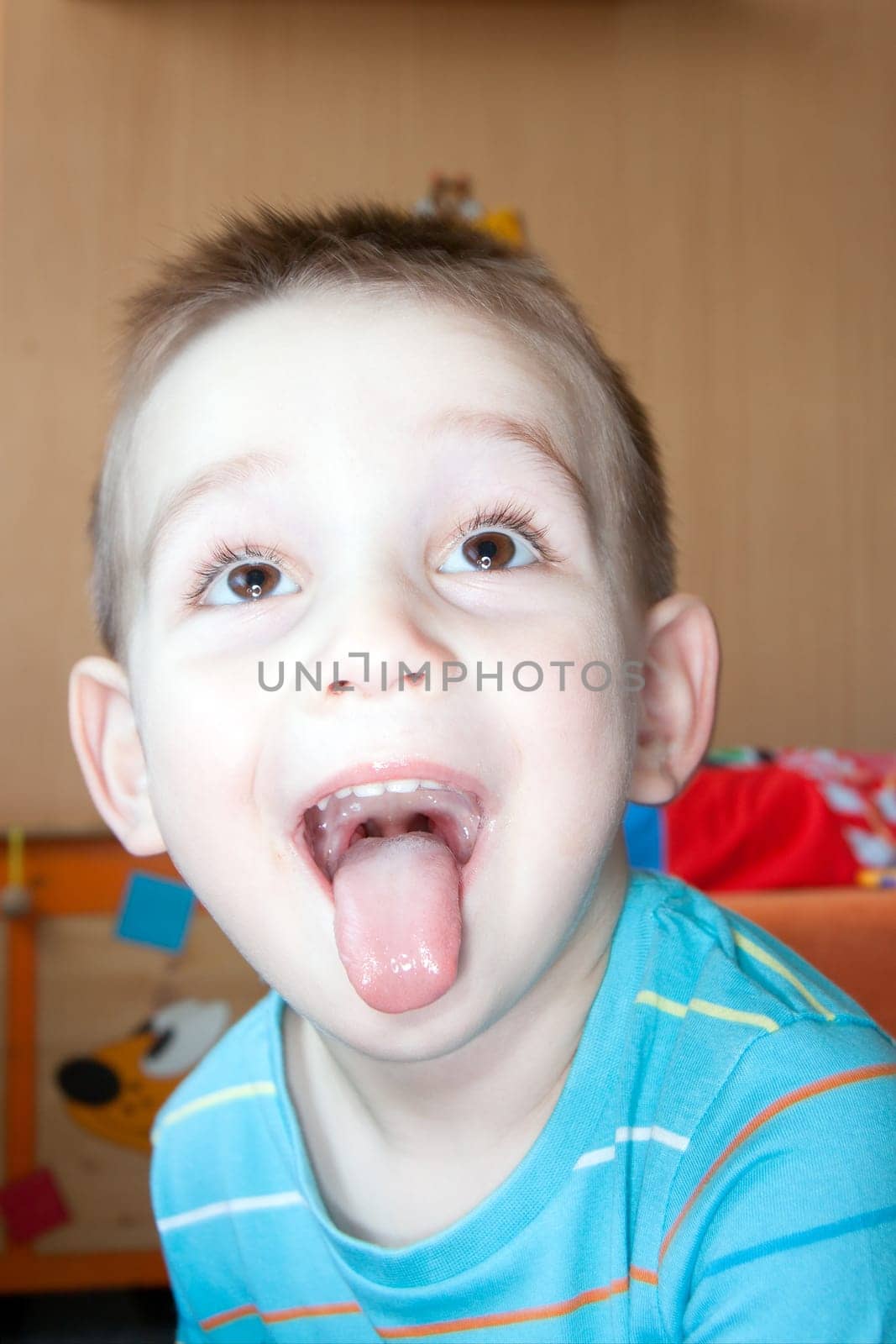detail of face boy with children's tongue at home