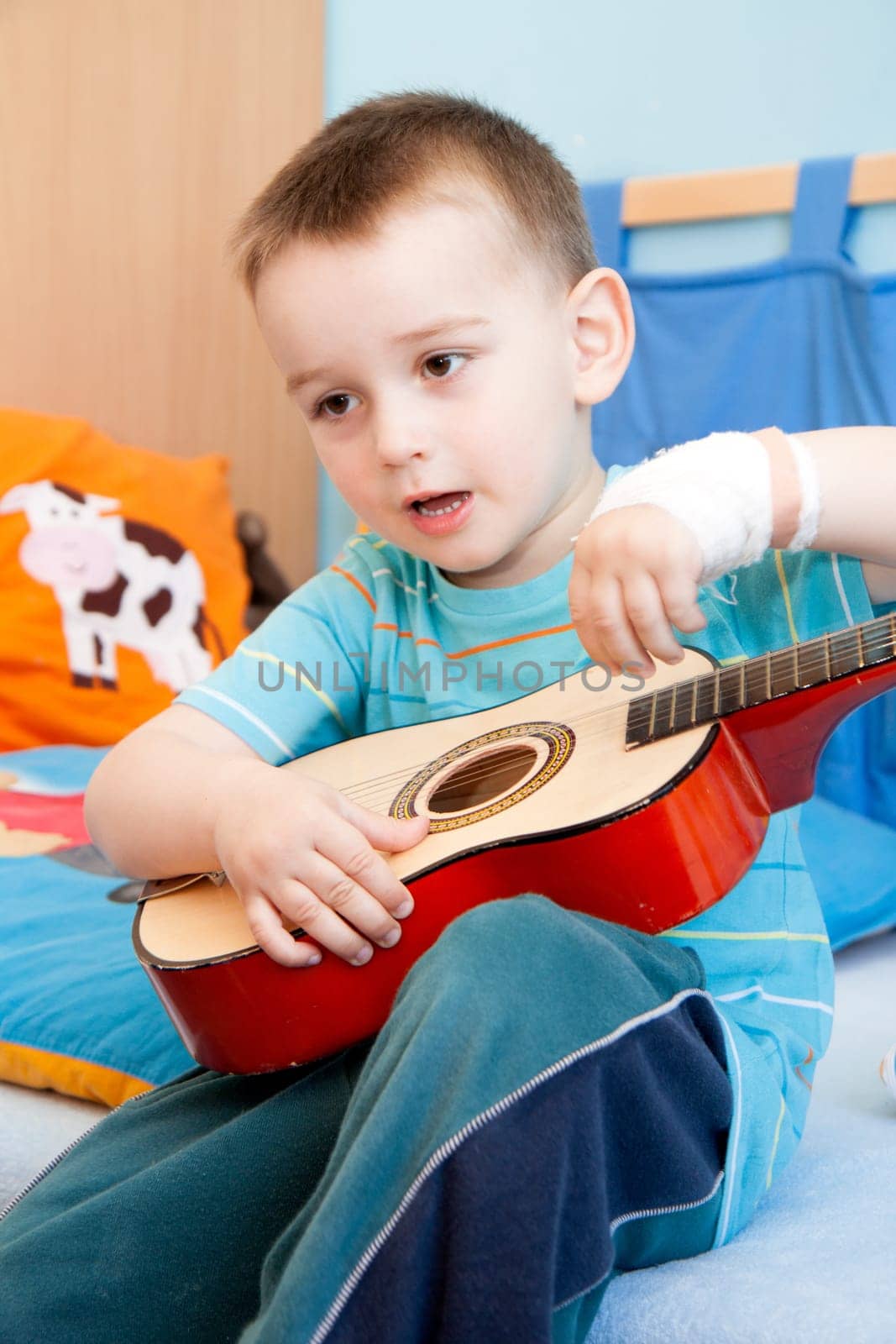 wounded in the left hand with bandage boy at shot in home with guitar