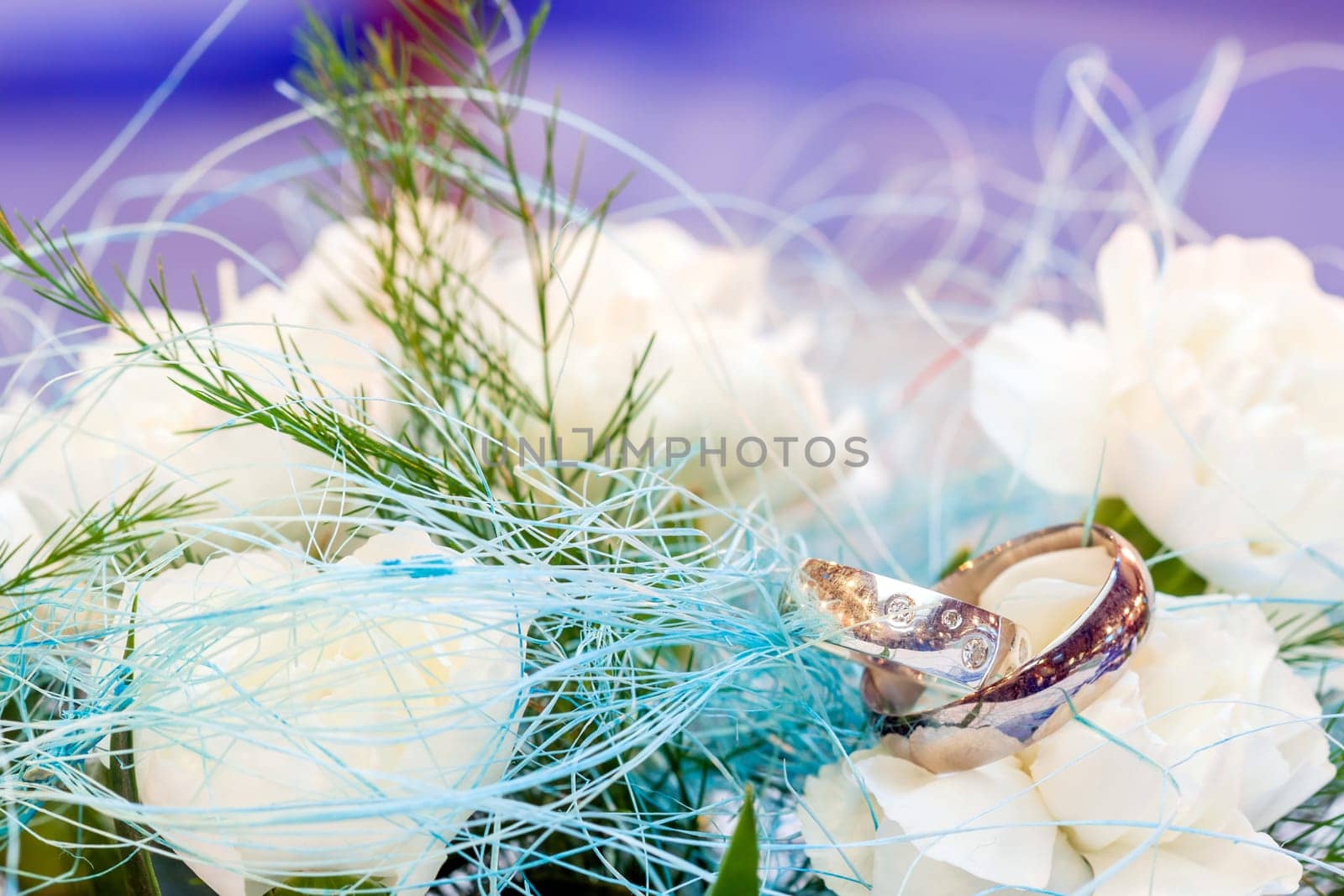 Wedding rings lying on white flower