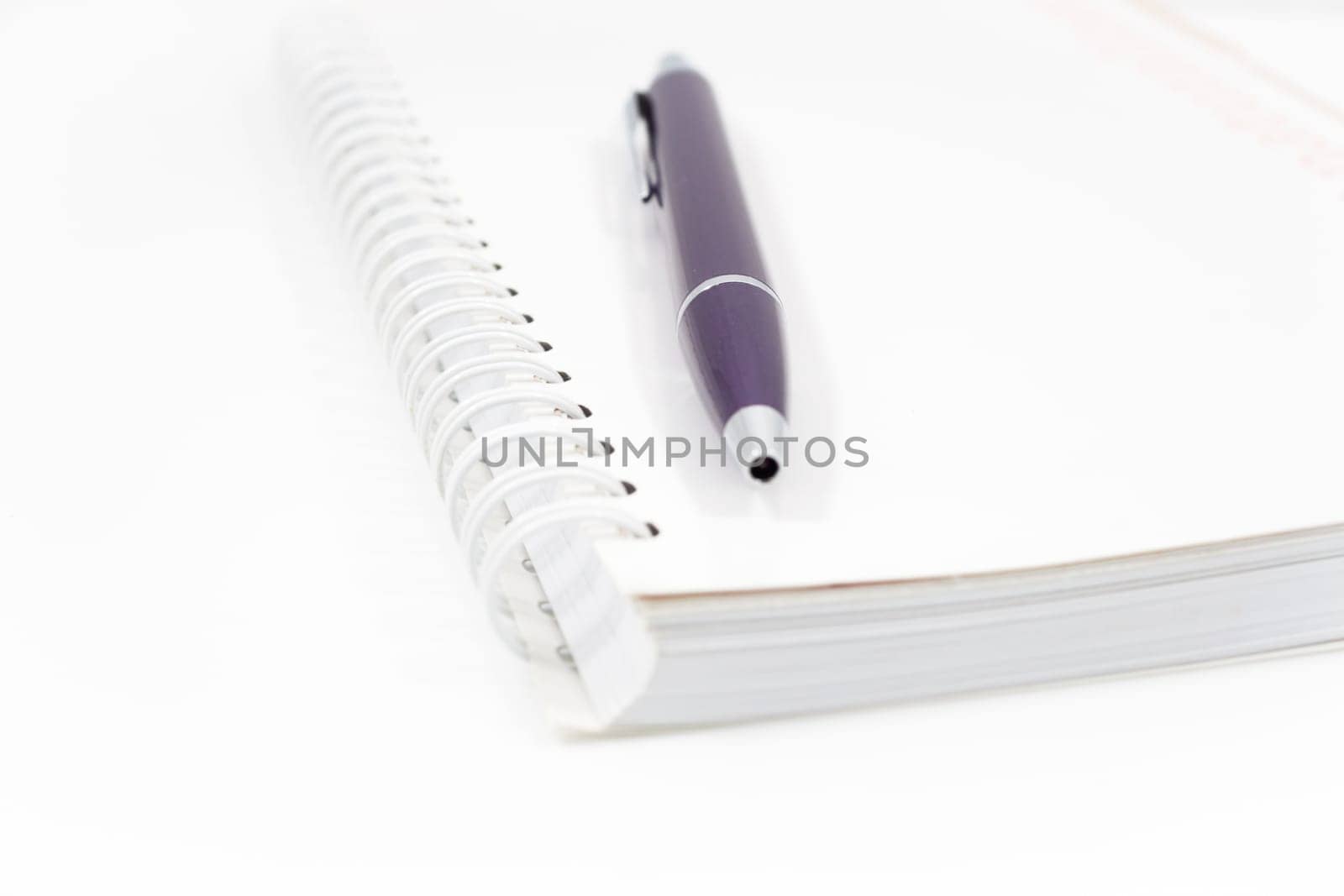 Spiral notebook with pen isolated on white background, stock photo