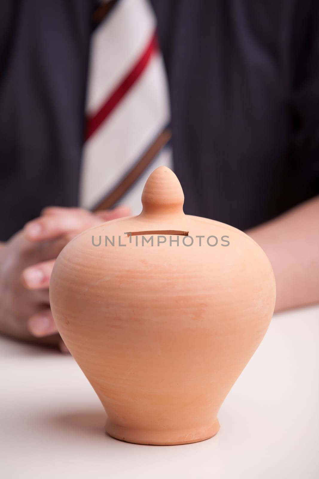 pottery clay moneybox means savings are needed and this office worker, maybe a clerk or an accountant, knows it very well