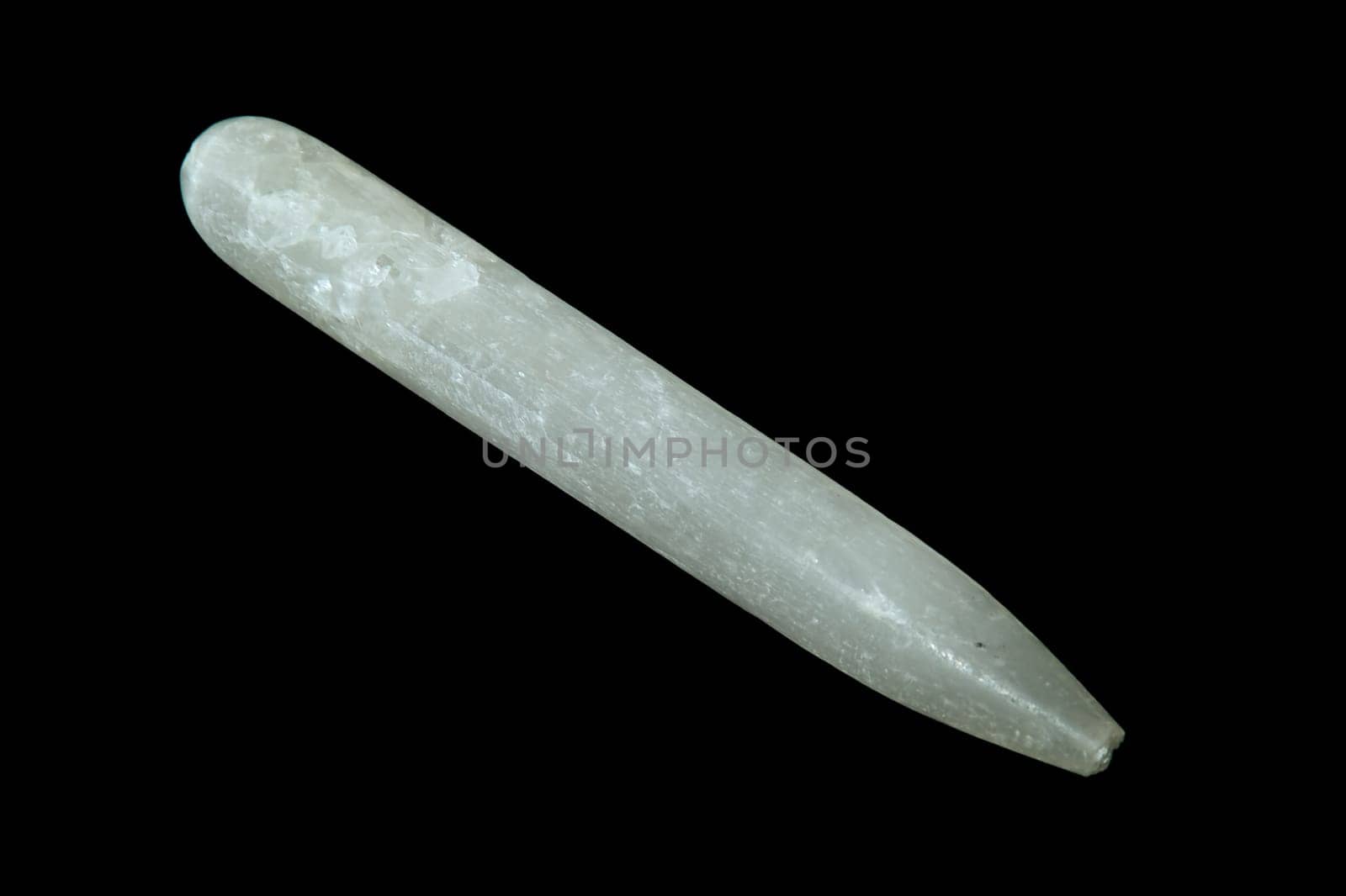 A selenite gypsum wand shot over black.
