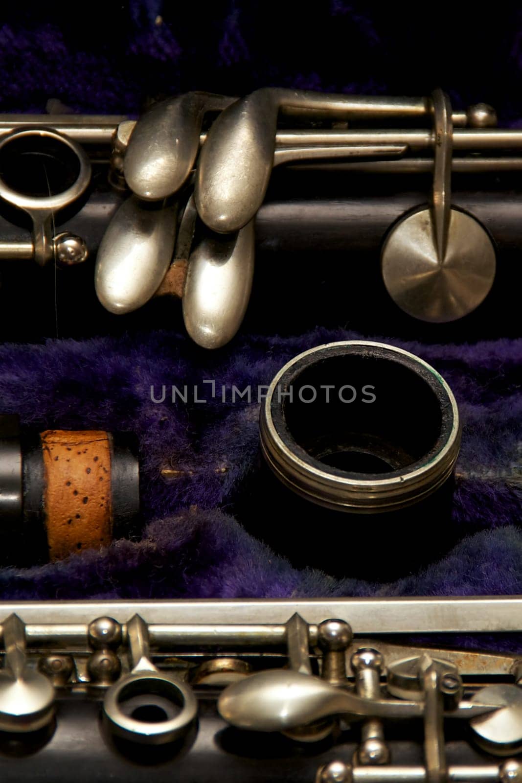 Parts of a clarinet are stored in blue lined case.