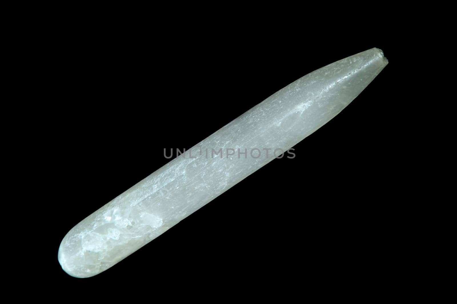 A selenite gypsum wand shot over black.