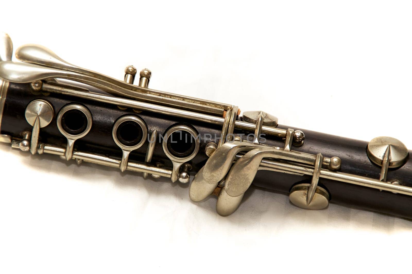 The body of a clarinet musical instrument shot over white.