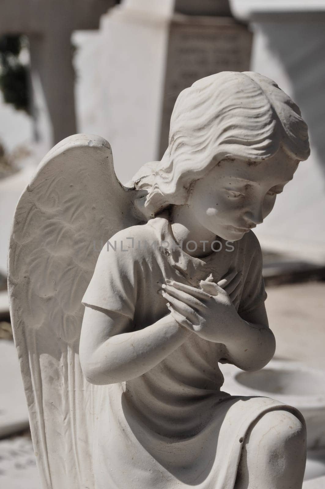 Praying angel marble funerary statue. Mourning cherub abstract.