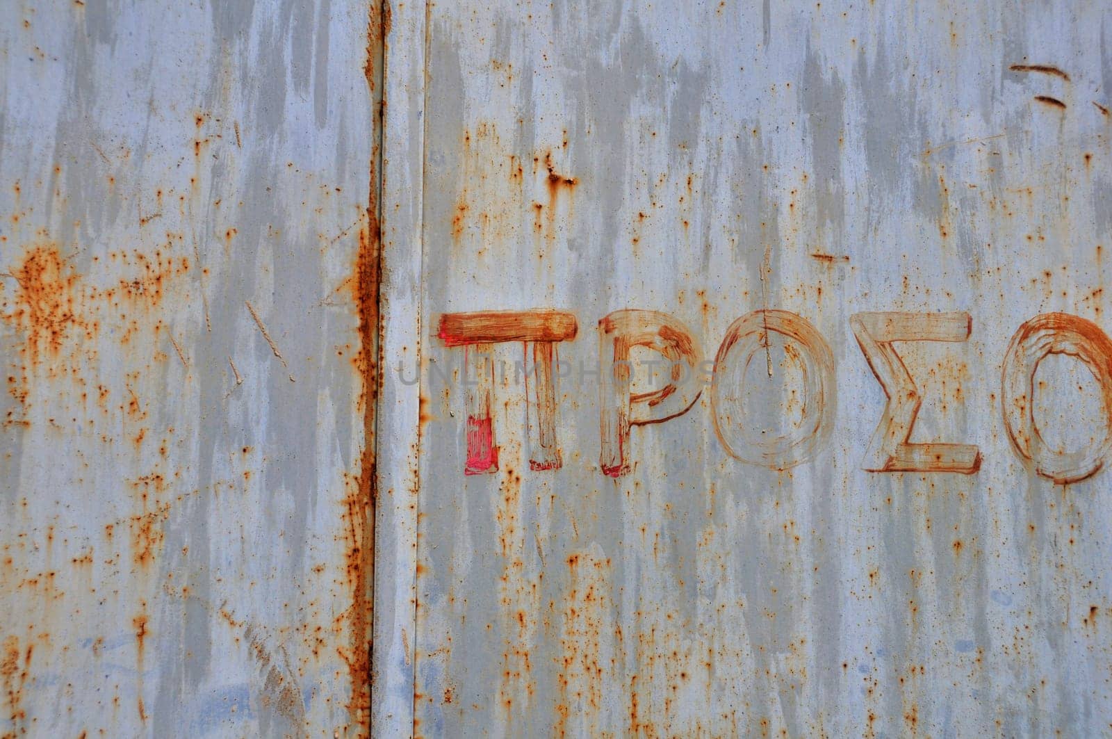 Rusty metal surface with hand painted typography. Abstract grunge background.