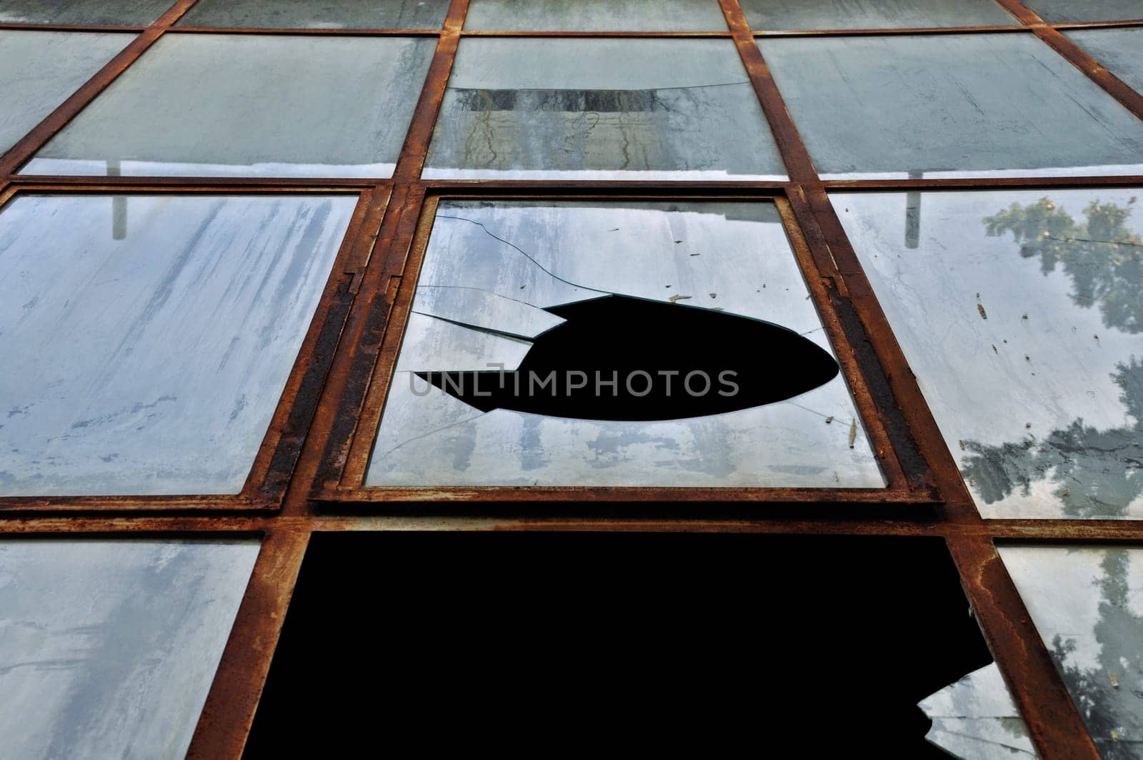 Smashed rusty windows of a decayed building. Abstract grunge background.