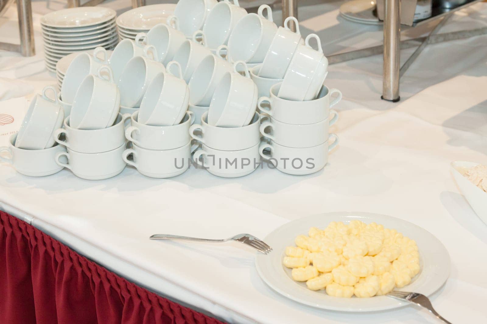 Stacks of cups and butter on a buffet