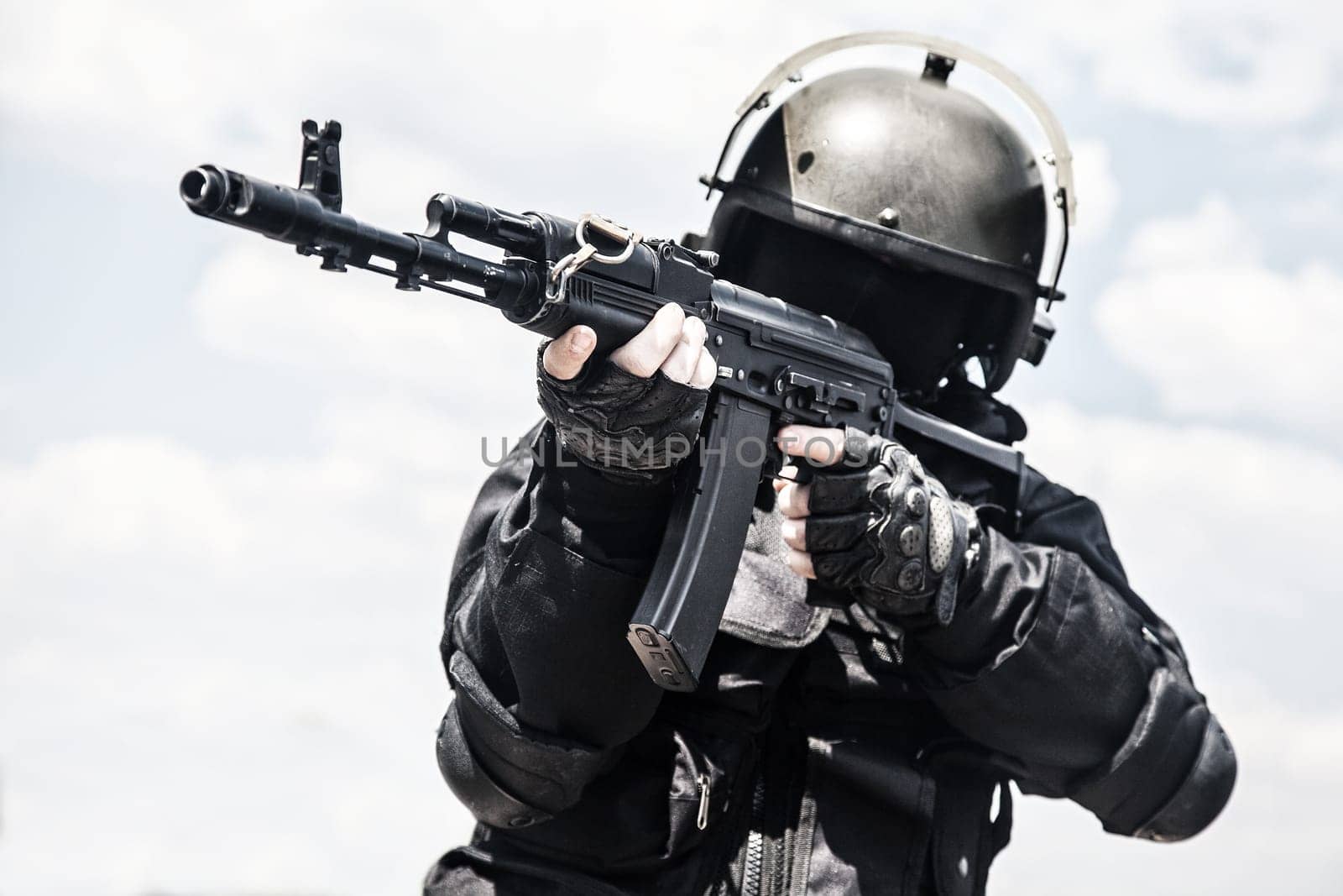 Spec ops soldier in black uniform and face mask with his rifle