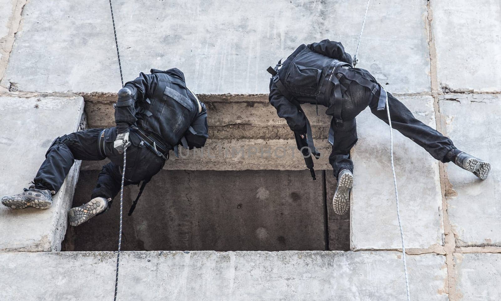 Spec ops soldier in face mask during rope exercises with weapons