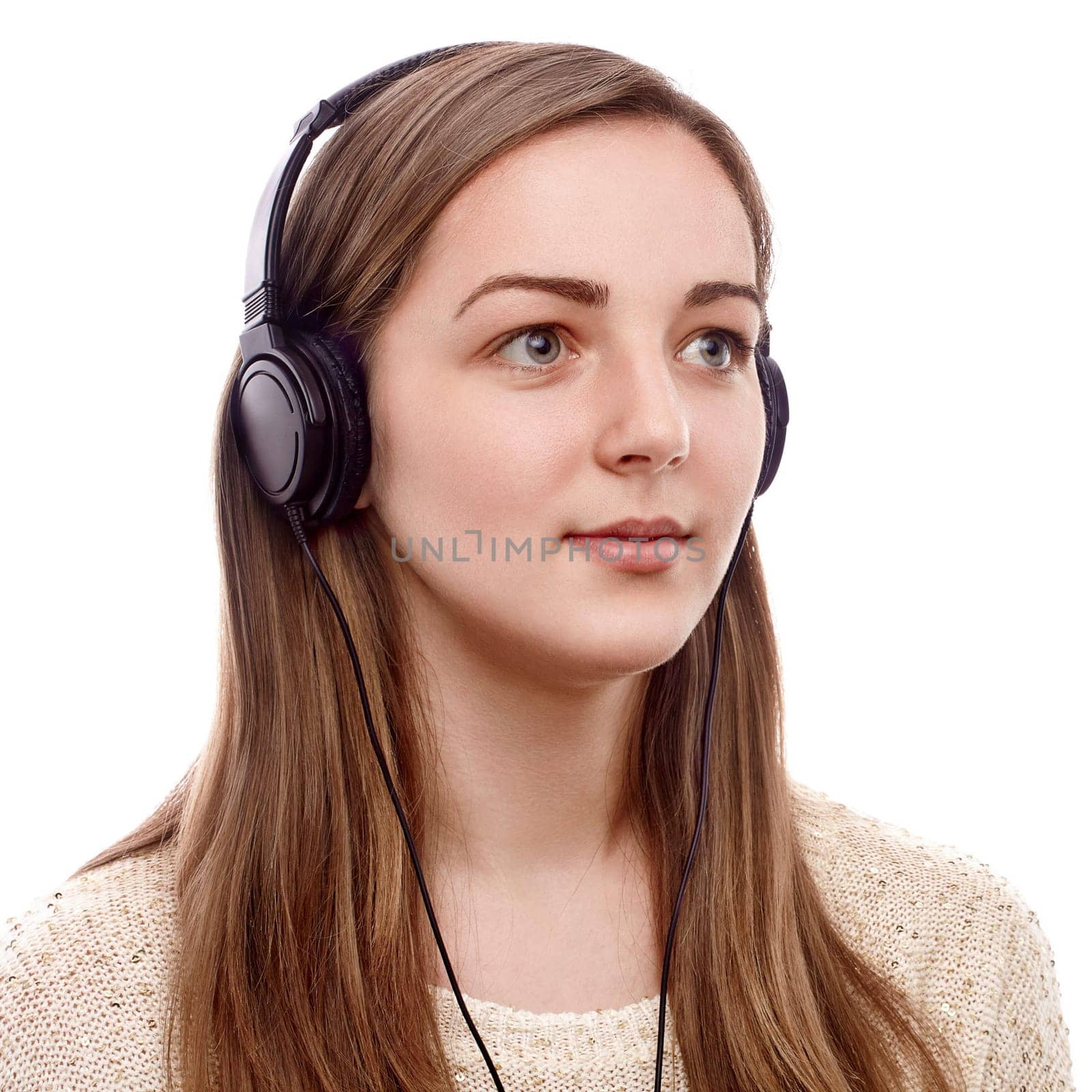 Young woman listening to the music on headphones