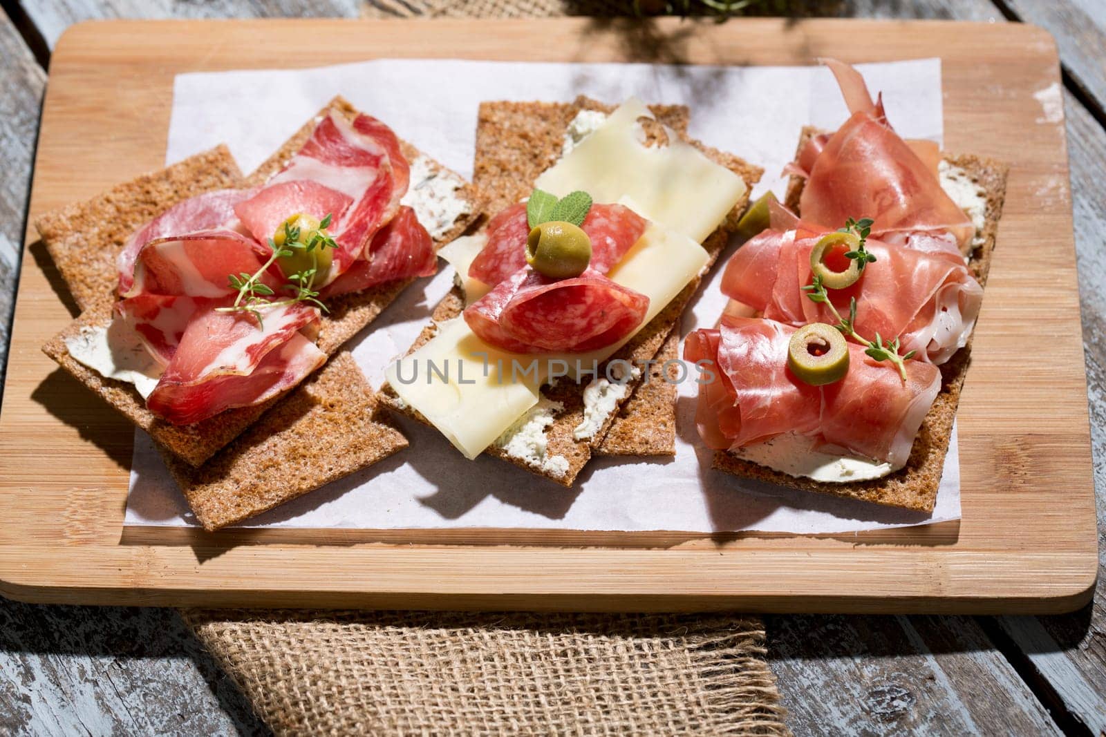 Finnish rye crispbread with salami Milano,Coppa ham,Prosciutto Crudo,Emmentaler,cream cheese with Herbs of Provence and Olive