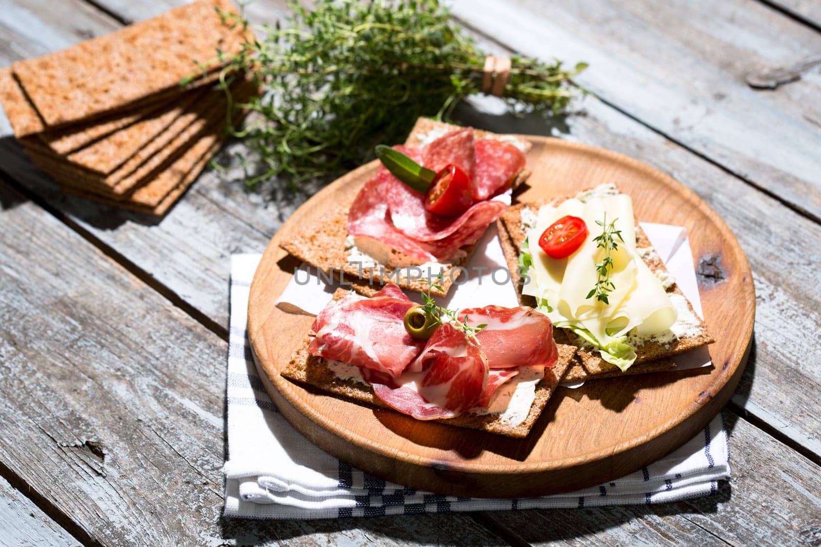 Finnish rye crispbread with salami Milano,Coppa ham,Prosciutto Crudo,Emmentaler,cream cheese with Herbs of Provence and Olive