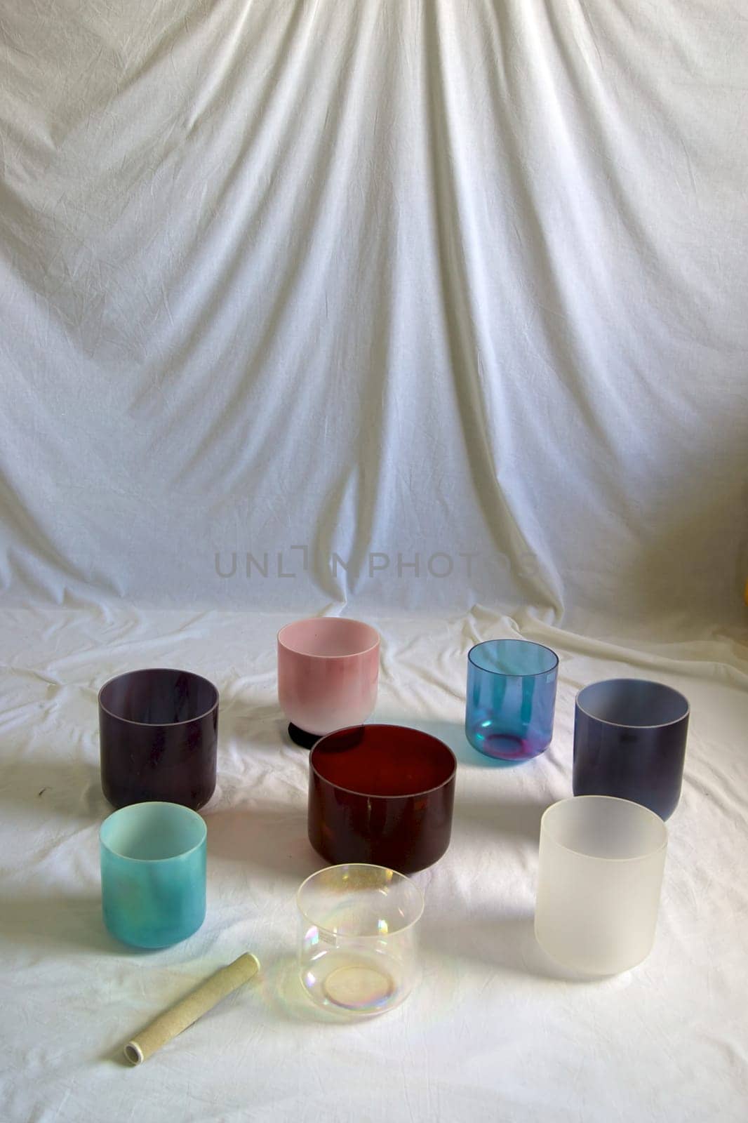 A collection of colorful crystal singing bowls against white backdrop.
