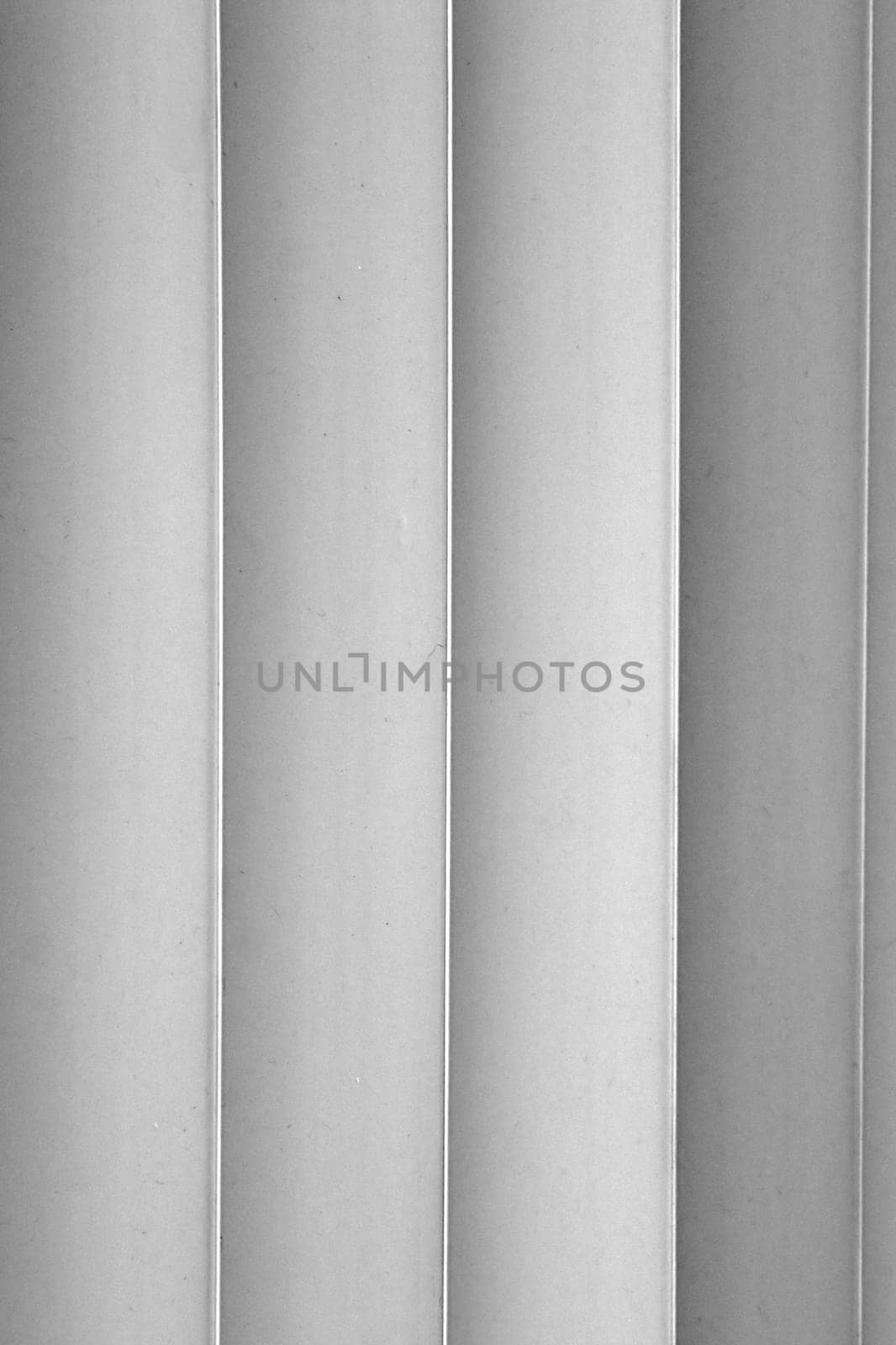 Image shows four slats of a vertical blind in black and white.