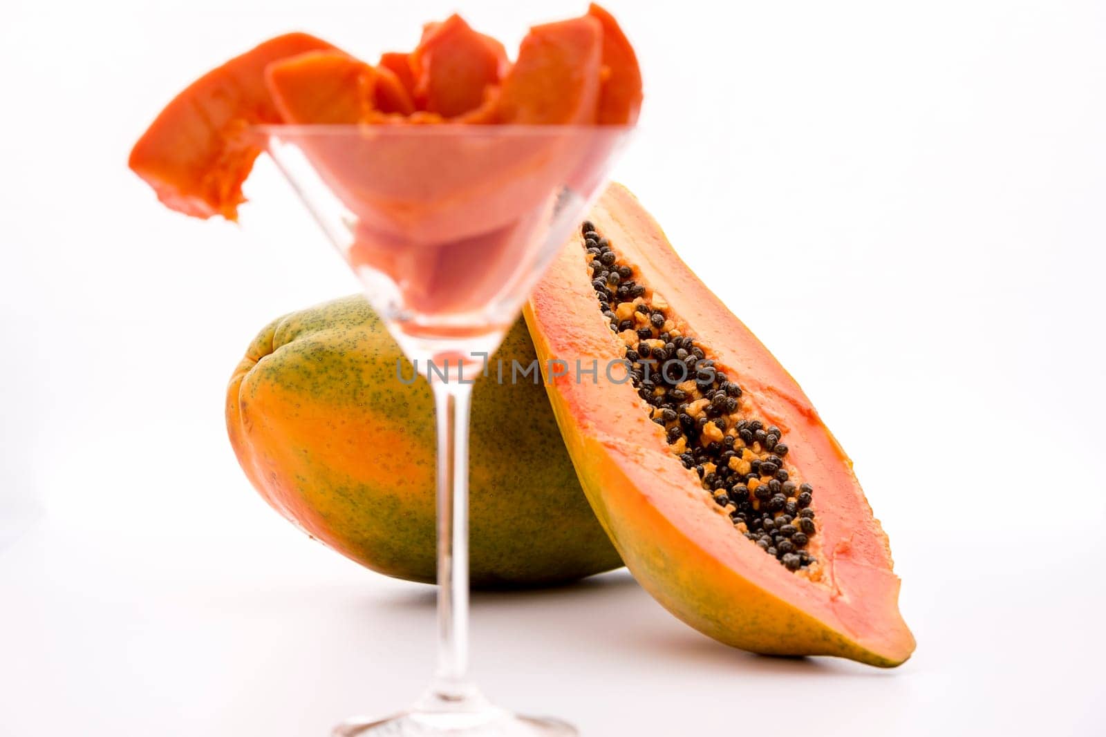 Blazing tangerine fruit pulp of the papaya revealed by a longitudinal cut through this tropical fruit..