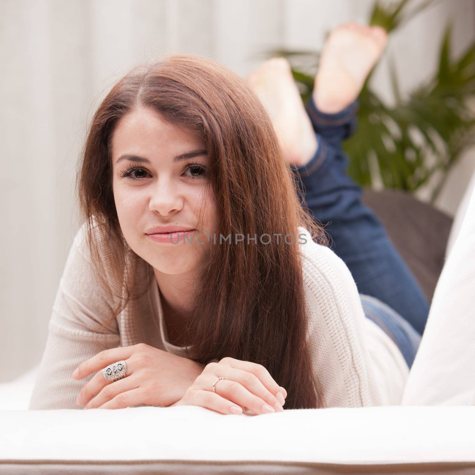 self confident beautiful young girl on a couch watching you and maybe a new idea she had