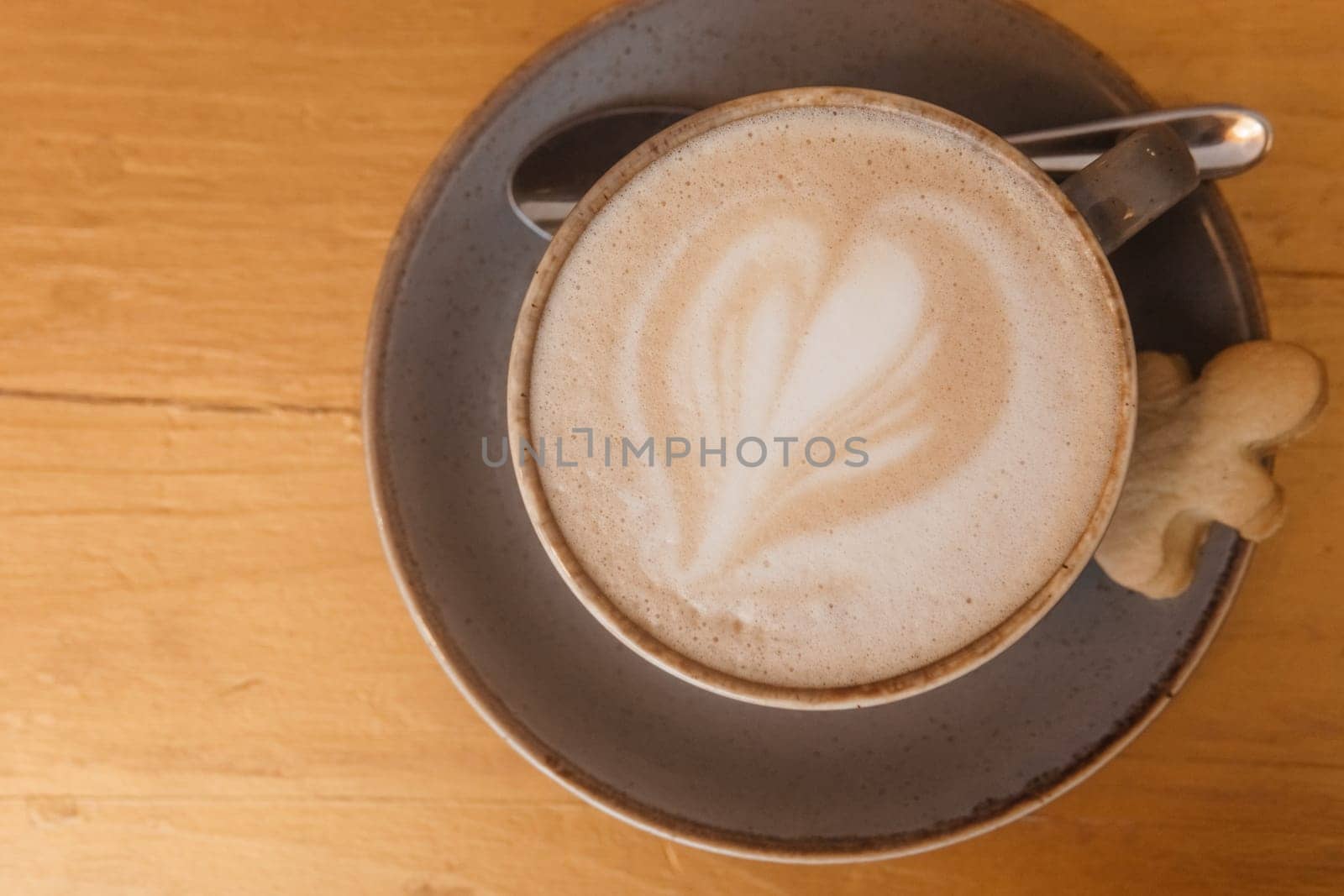 Coffee on a wooden table in a cafe, drawings on coffee. by Annu1tochka