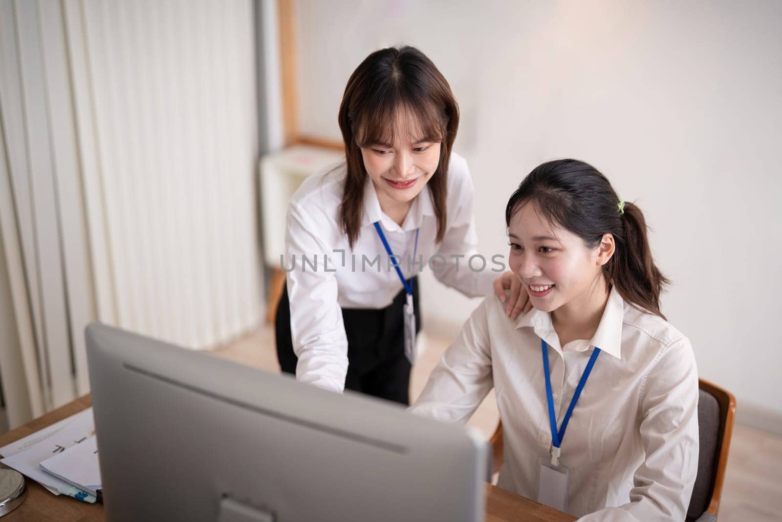 Asian company employee and colleague work together in the office. by talking and giving advice.