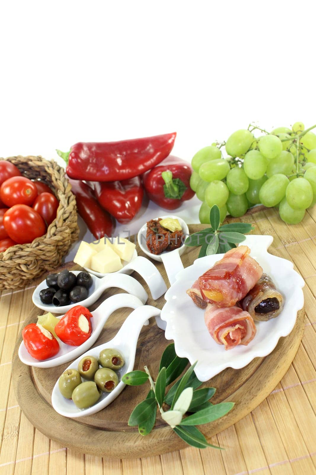 various tapas in serving spoons on a wooden board