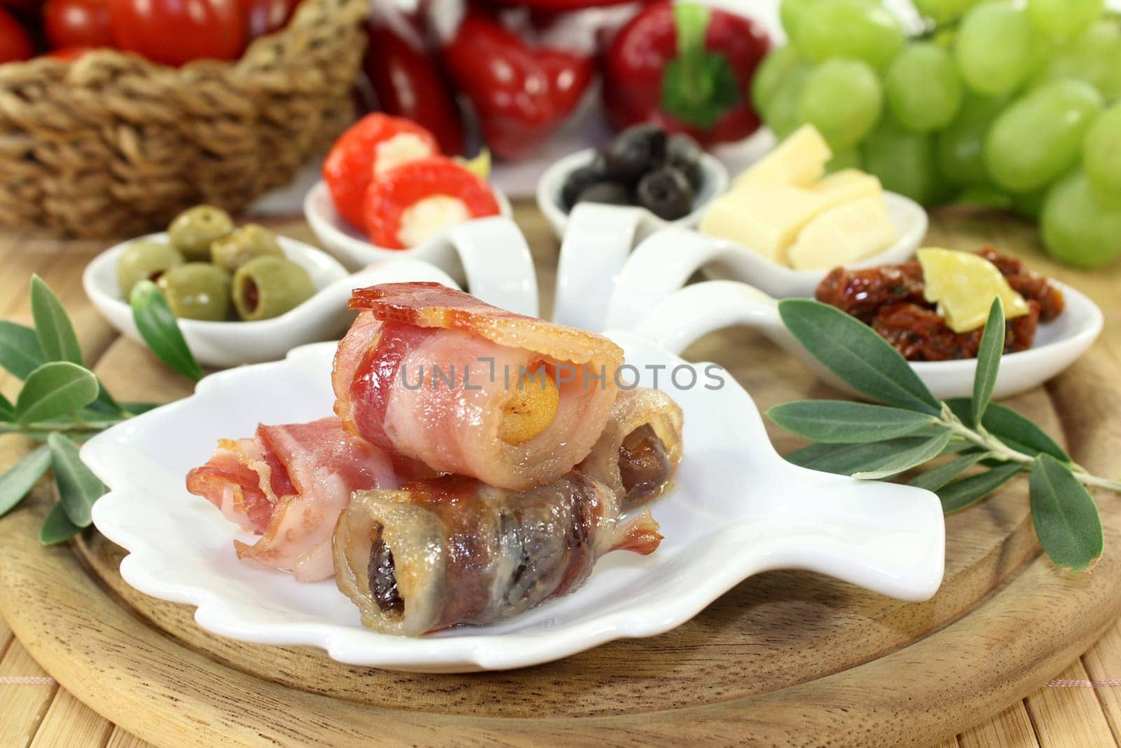 various tapas in serving spoons on a wooden board