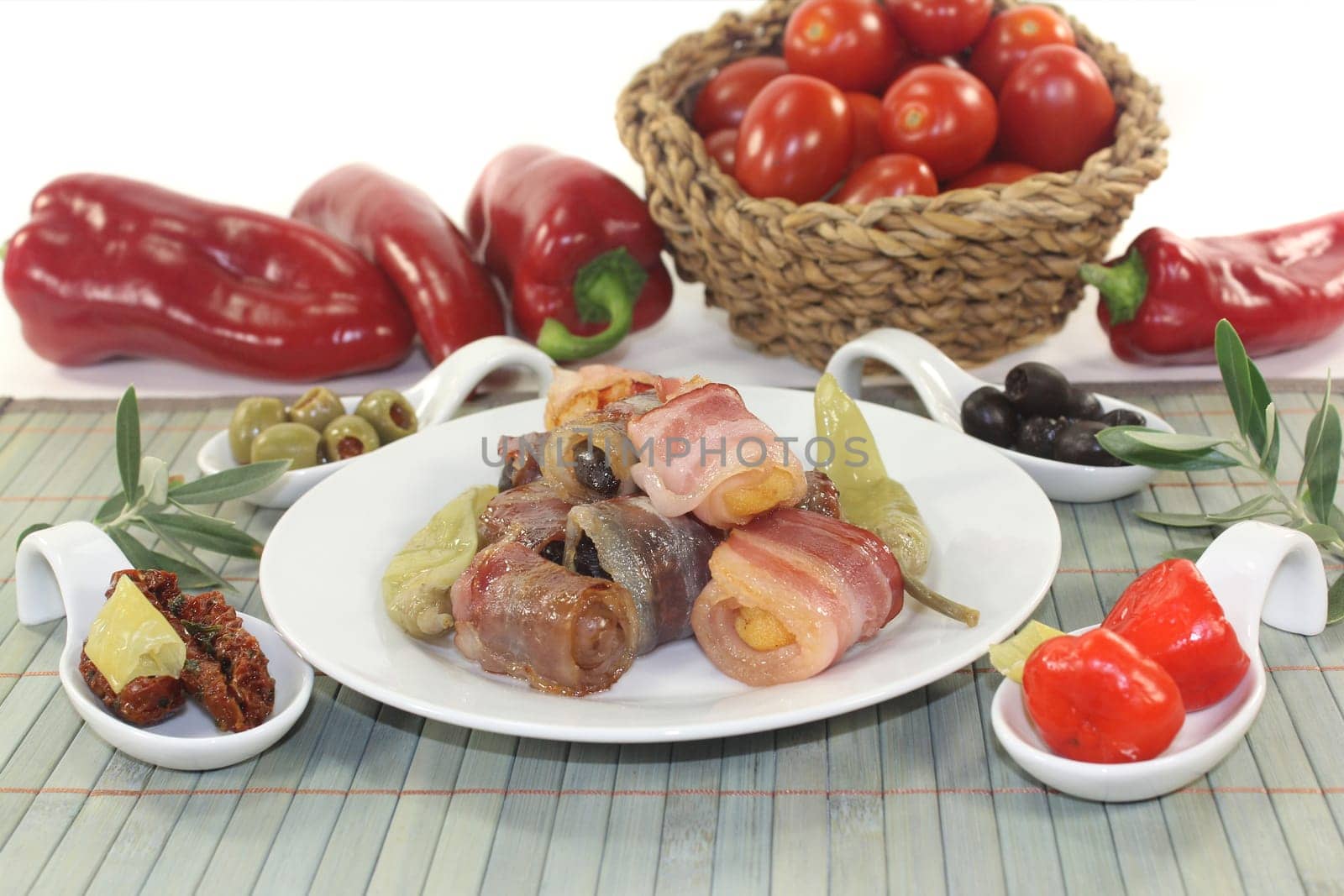 various tapas in serving spoons on a wooden mat