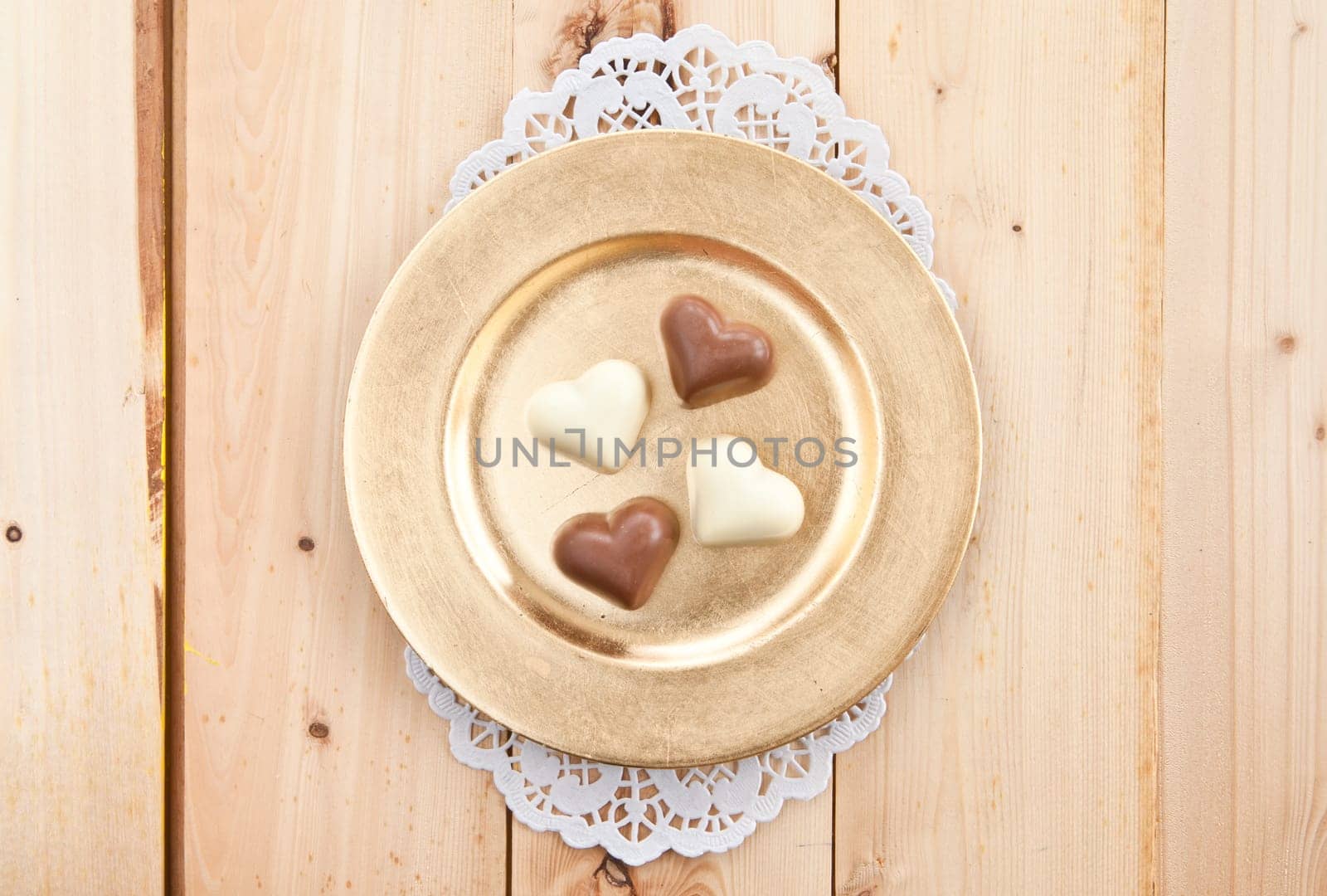 Hearts of white and dark chocolate on a golden plate
