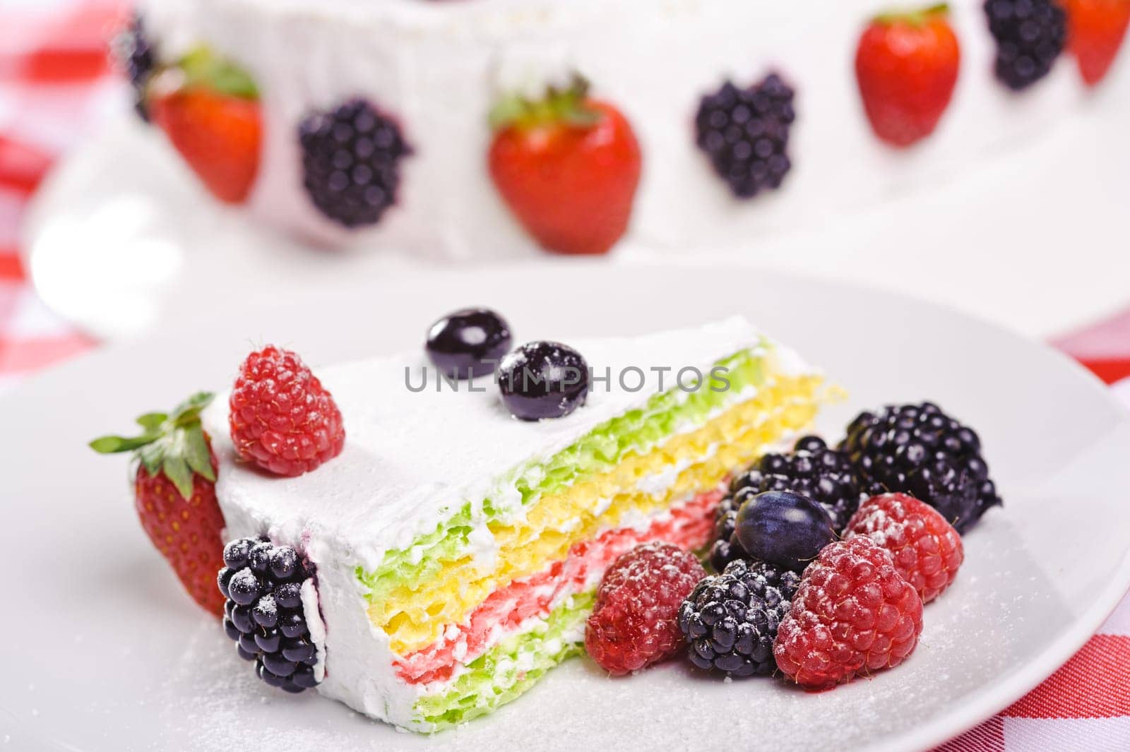 Piece of cake on plate with berries and fruits