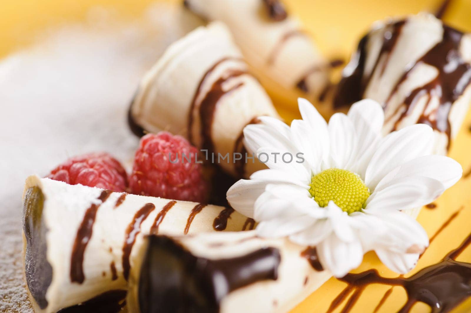 Piece of cake on plate with berries and fruits and camomile