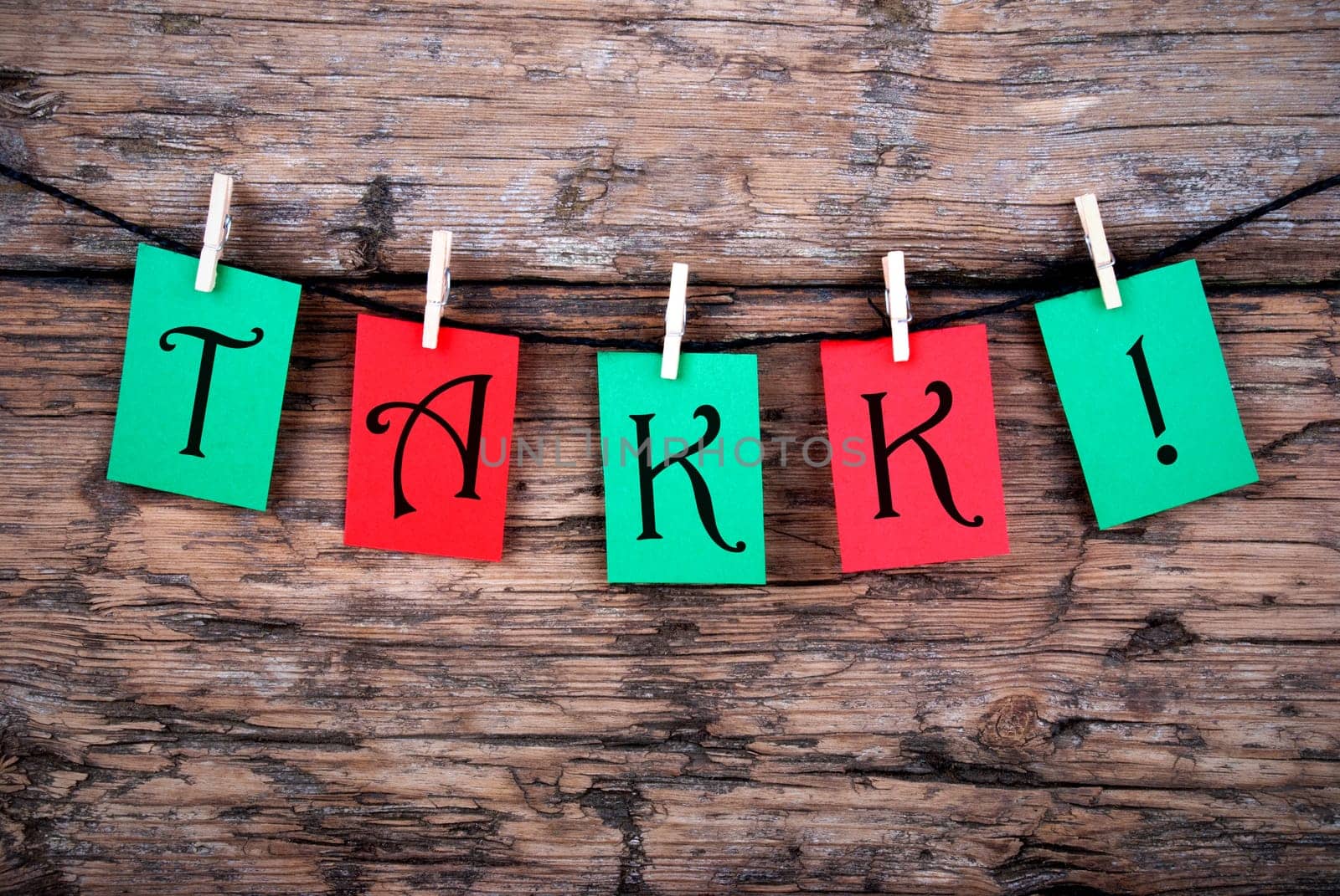 Tha Norwegian and Danish Word Takk, which means Thanks, on a Wooden Background