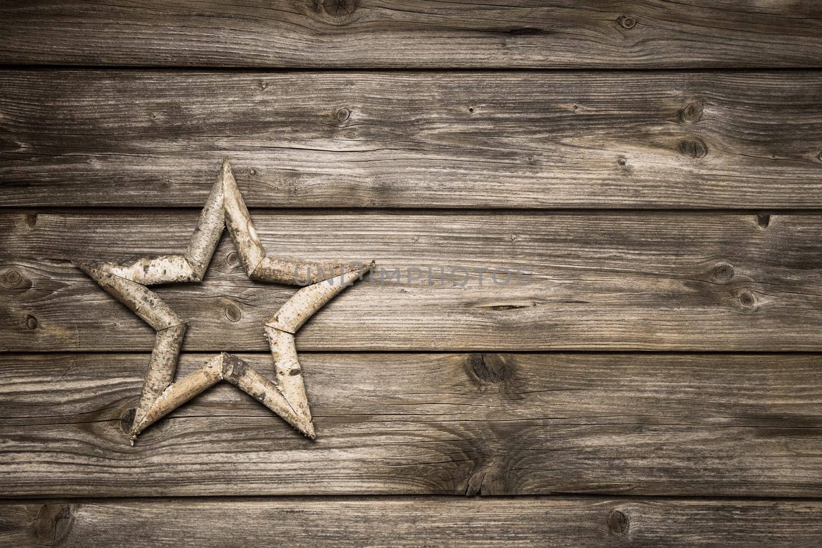 Wooden christmas background with a handmade star for decoration.