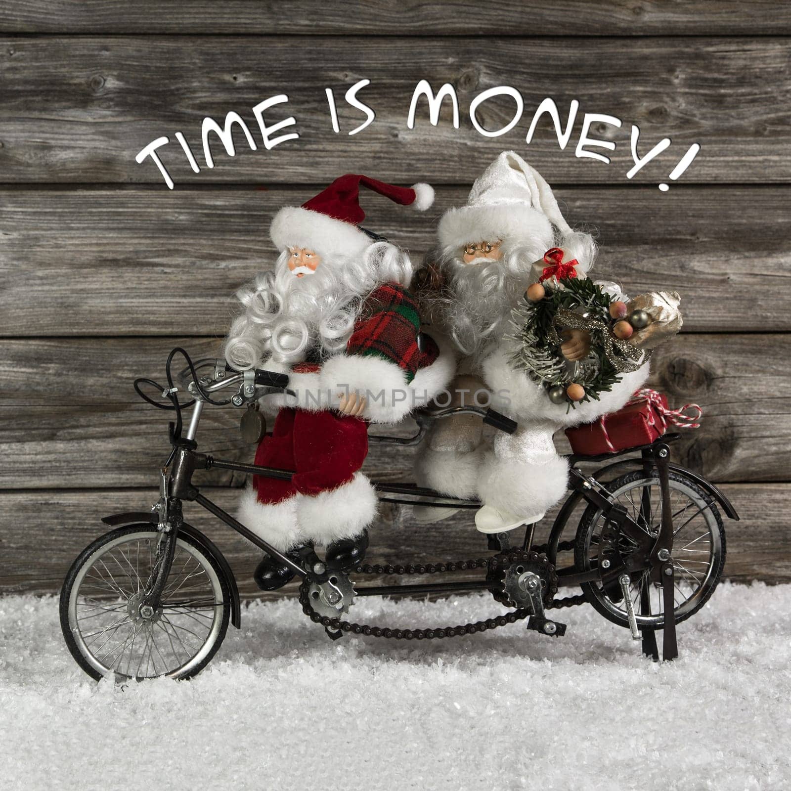Time is money - santa claus team in rush for buying christmas presents. Funny photo in vintage style with an old tandem bike of tin.