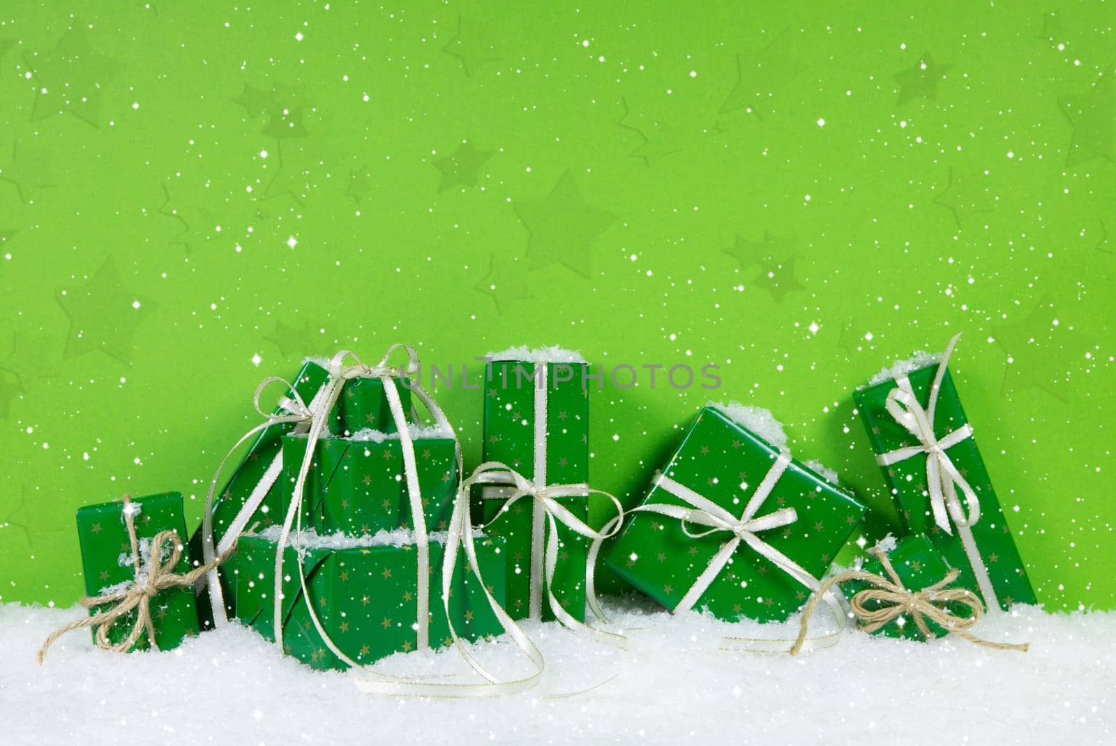 Green christmas presents on white snowy background.