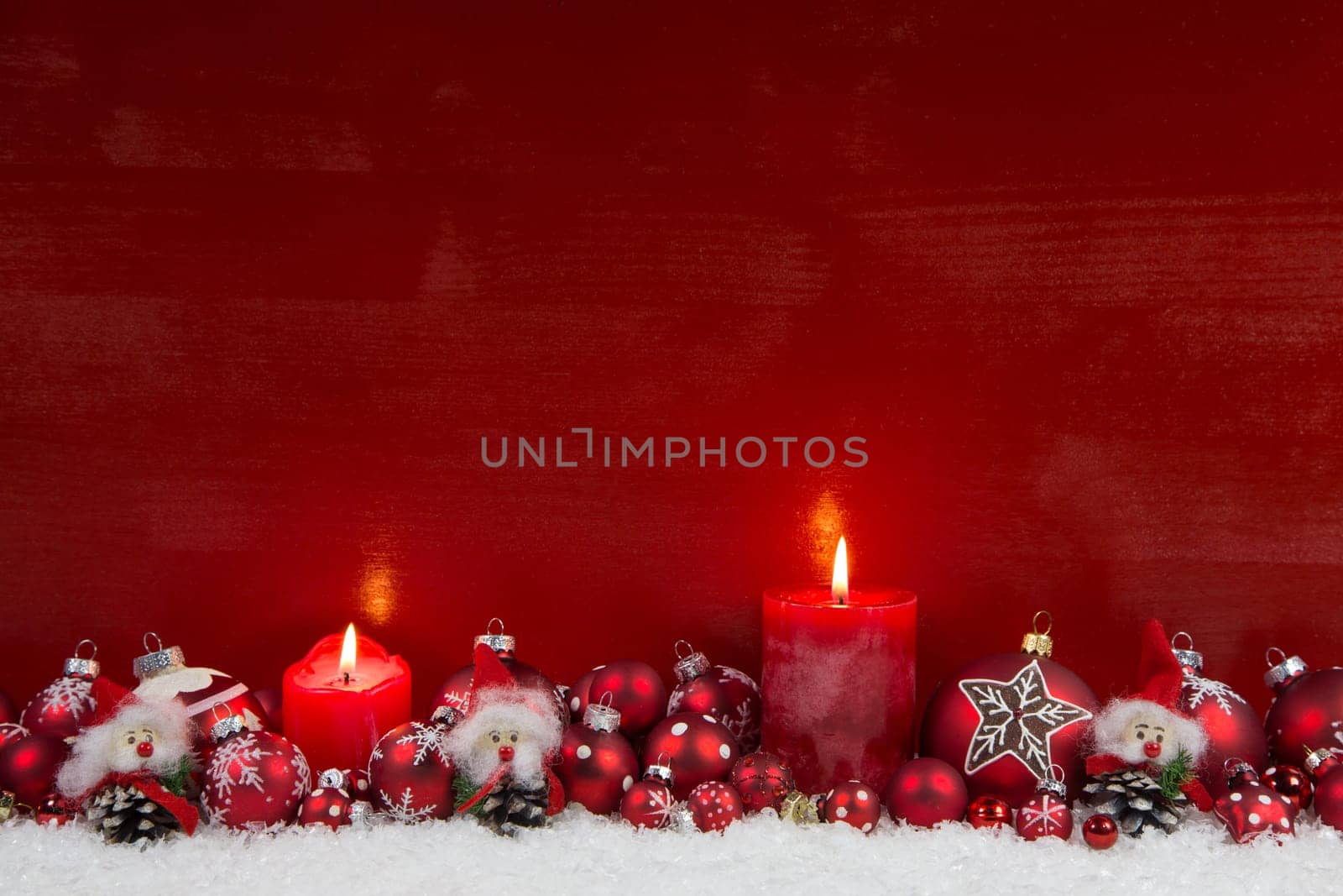 Red wooden christmas background with two burning candles - classic decoration.
