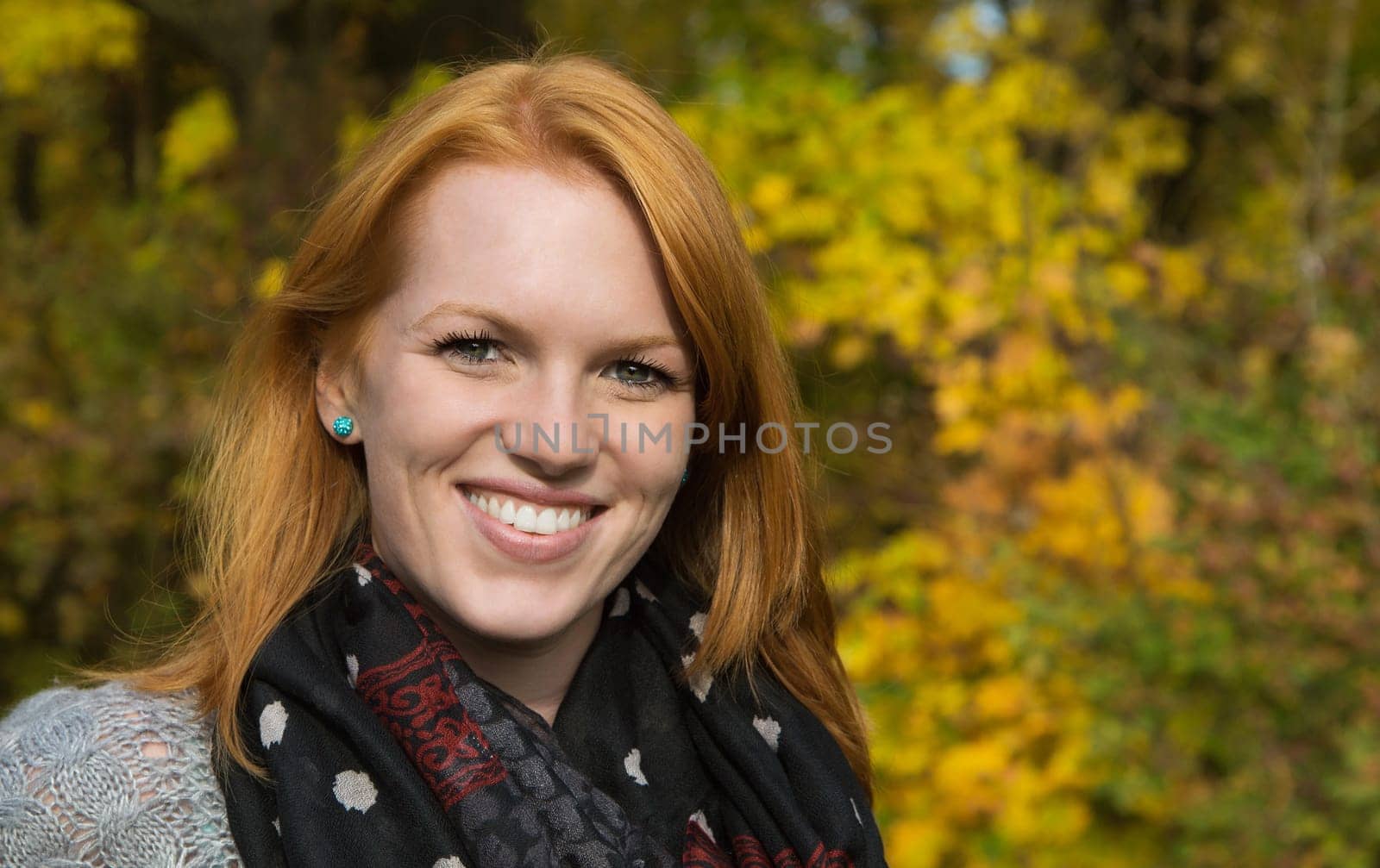 Portrait, Natural red-haired young smiling woman in autumn on a walk.