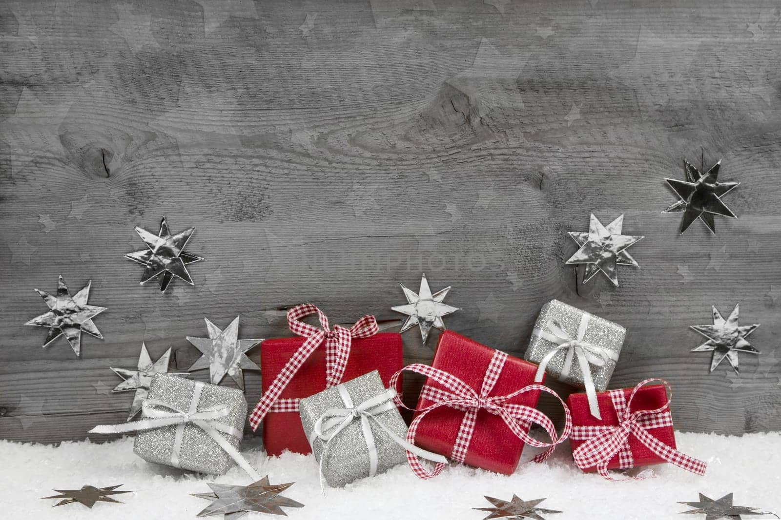 Christmas presents in red and silver on wooden grey wooden background.
