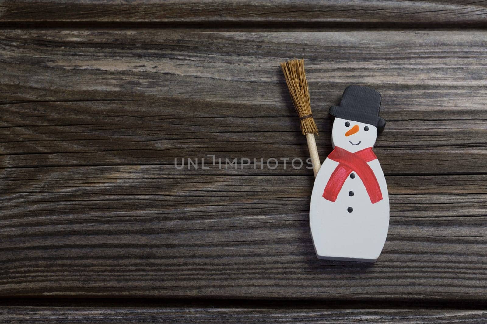 Snowman in red and white color on wooden background for christmas decoration.