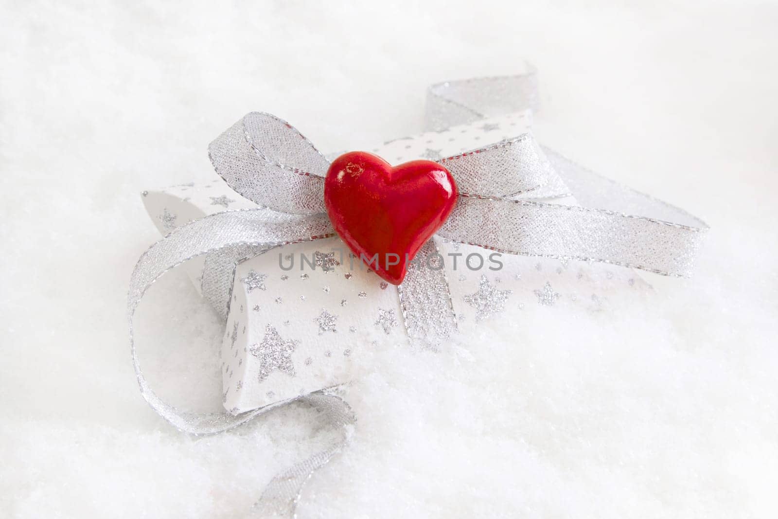 Top view of white and silver present box with red heart for christmas