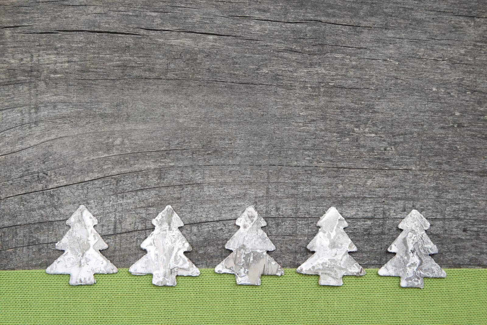 Wooden Christmas trees with green fabric on grey wooden background