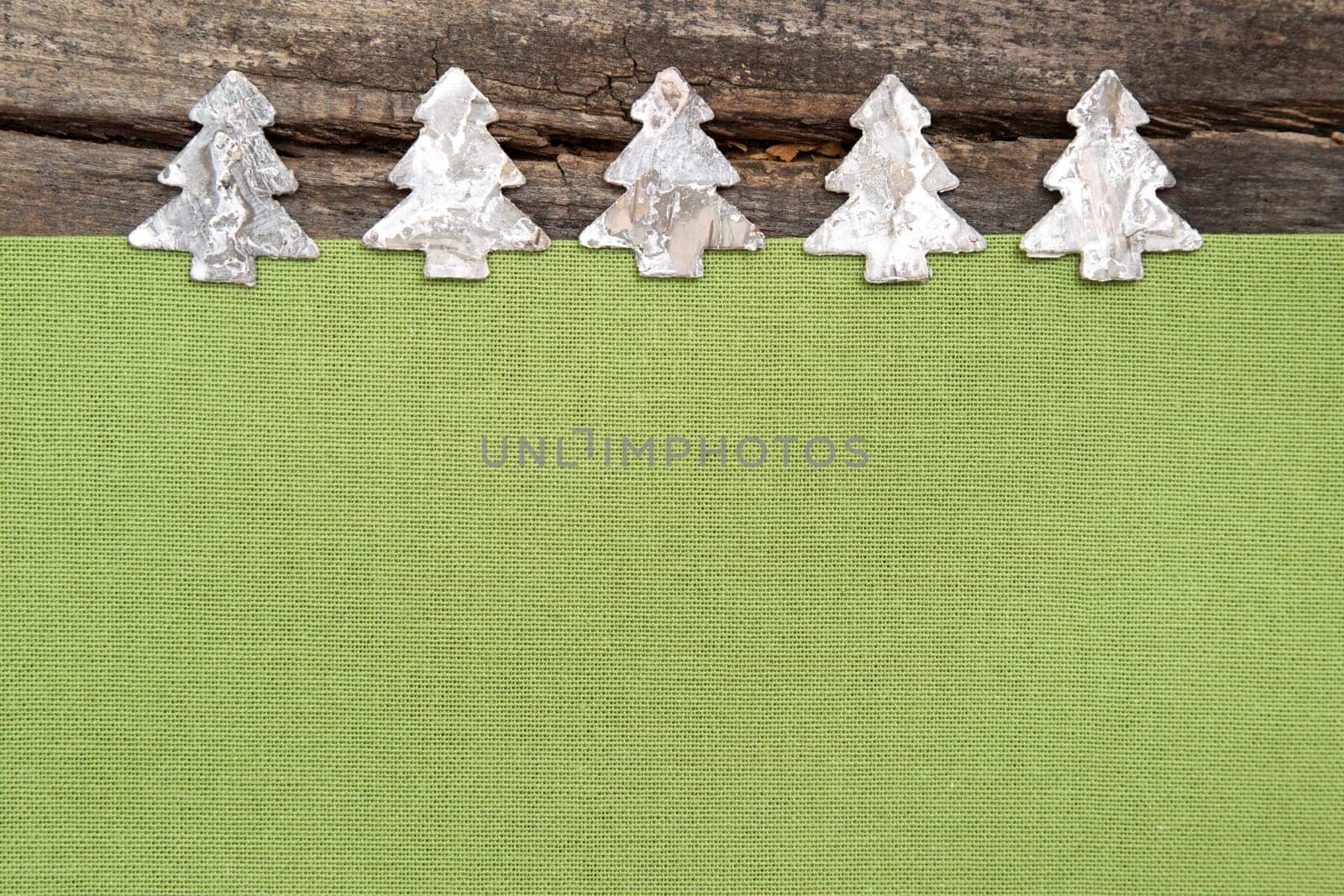 Wooden Christmas trees with green fabric on grey wooden background for a greeting card