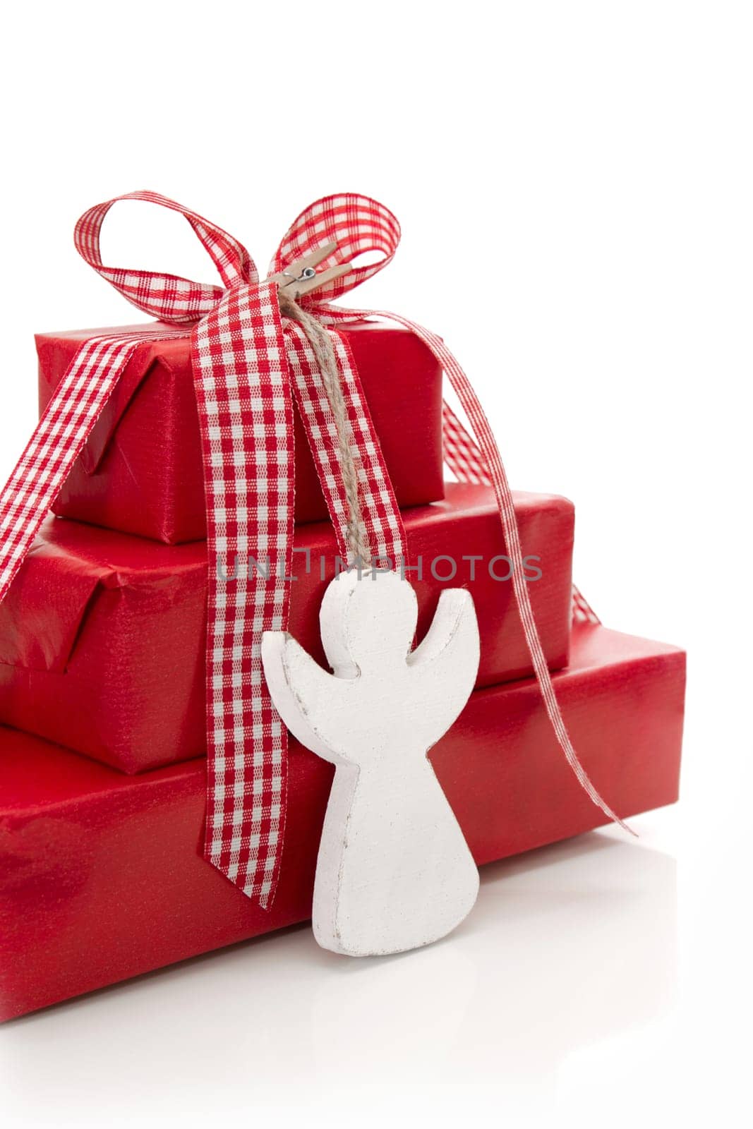 Red christmas presents with a white wooden angel an red checkered ribbon isolated in Country style