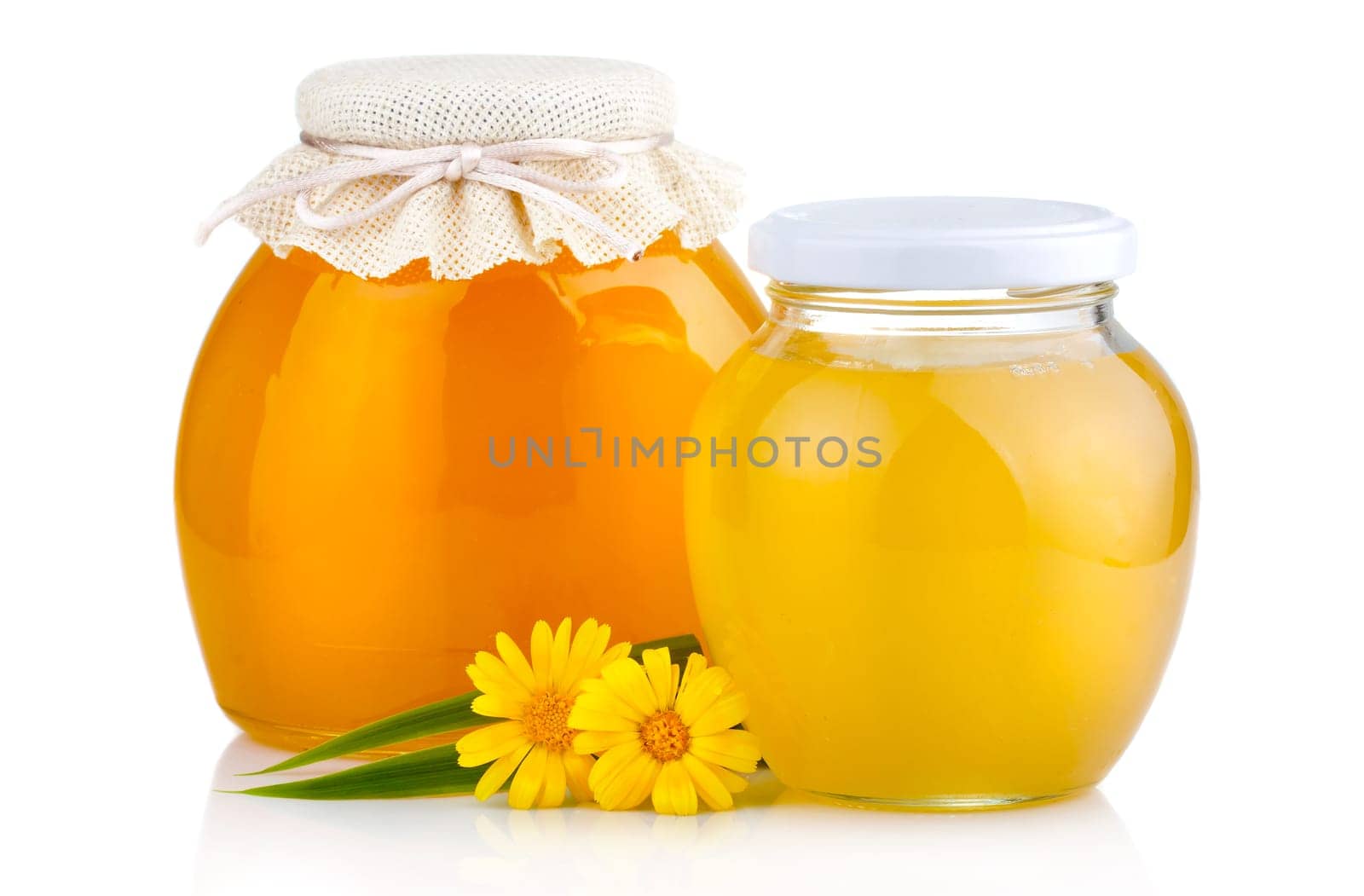 Sweet honey pouring from wooden dipper in glass bowl isolated on white