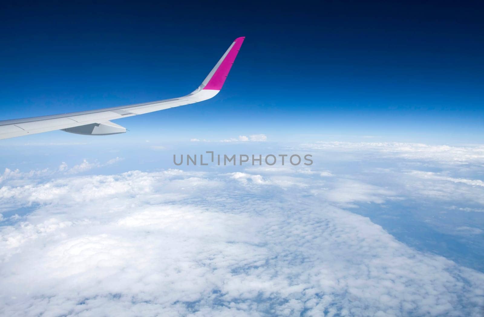 Plane wing and clouds viewed from airplane