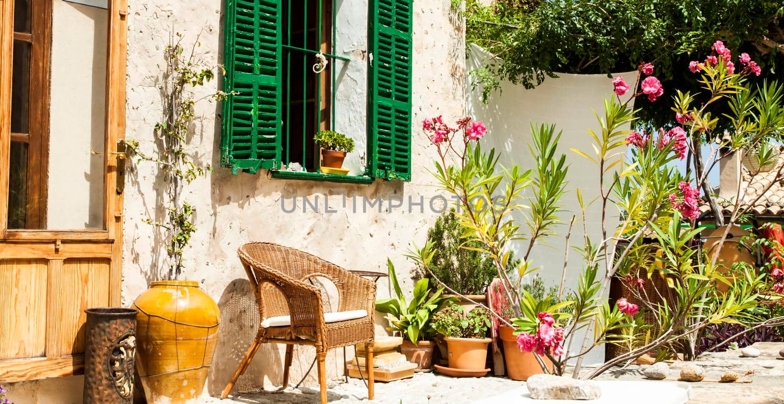 Traditional courtyard with chairs and a lot o flowers in old village in Mallorca island, Spain