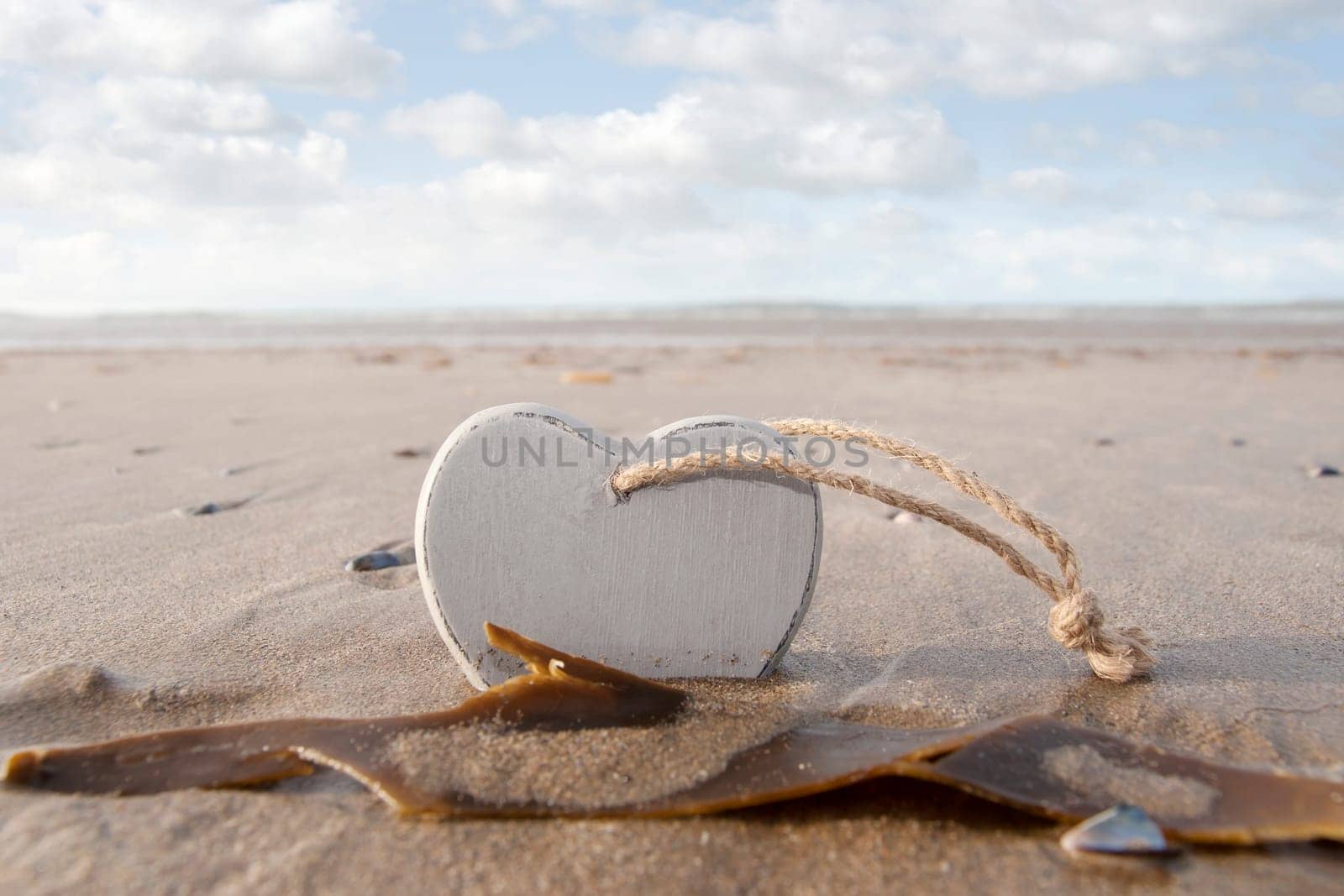 single wooden love heart in the sand on a wild Atlantic way Irish beach in summer