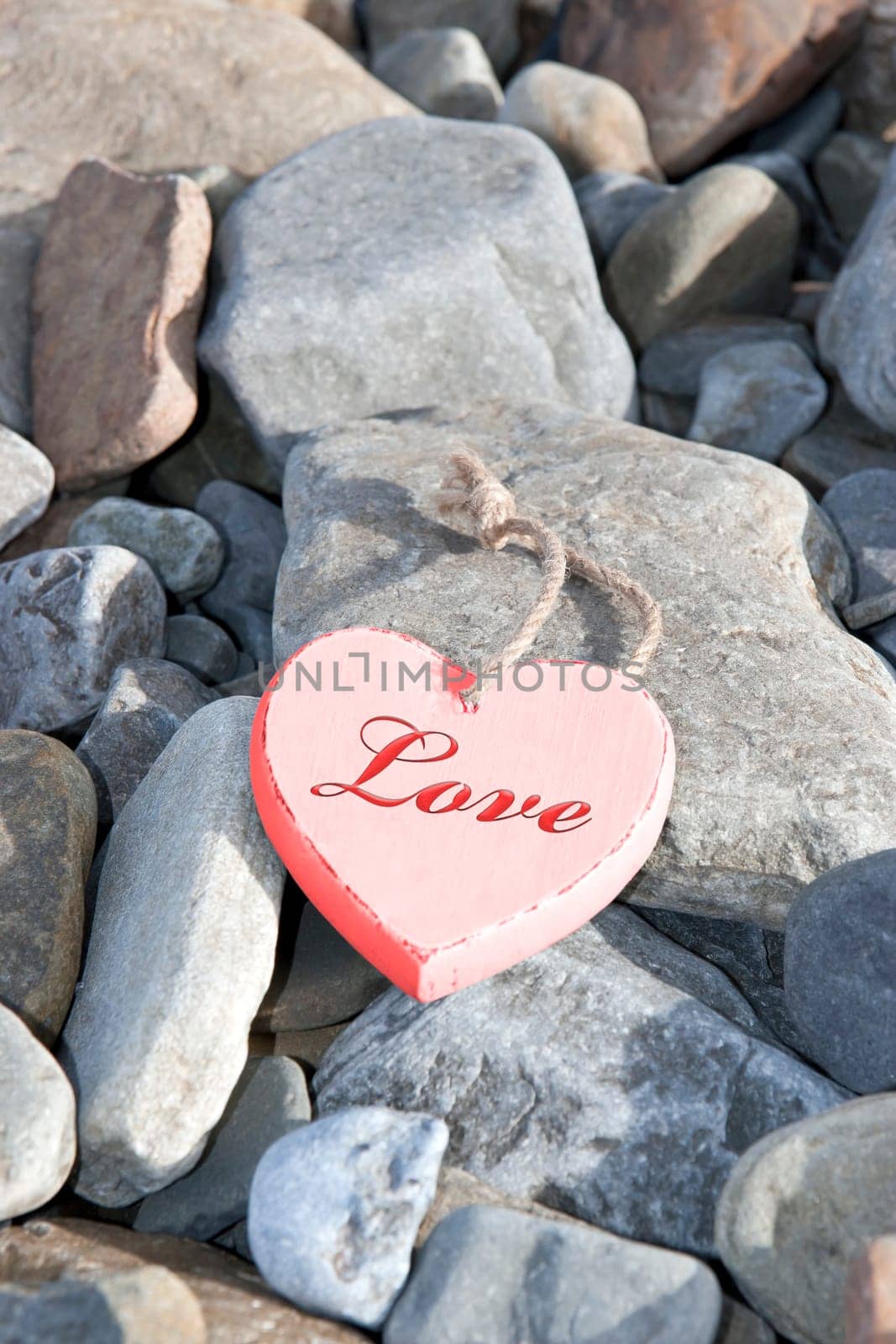 single red wooden love heart on a pebble beach in Ireland